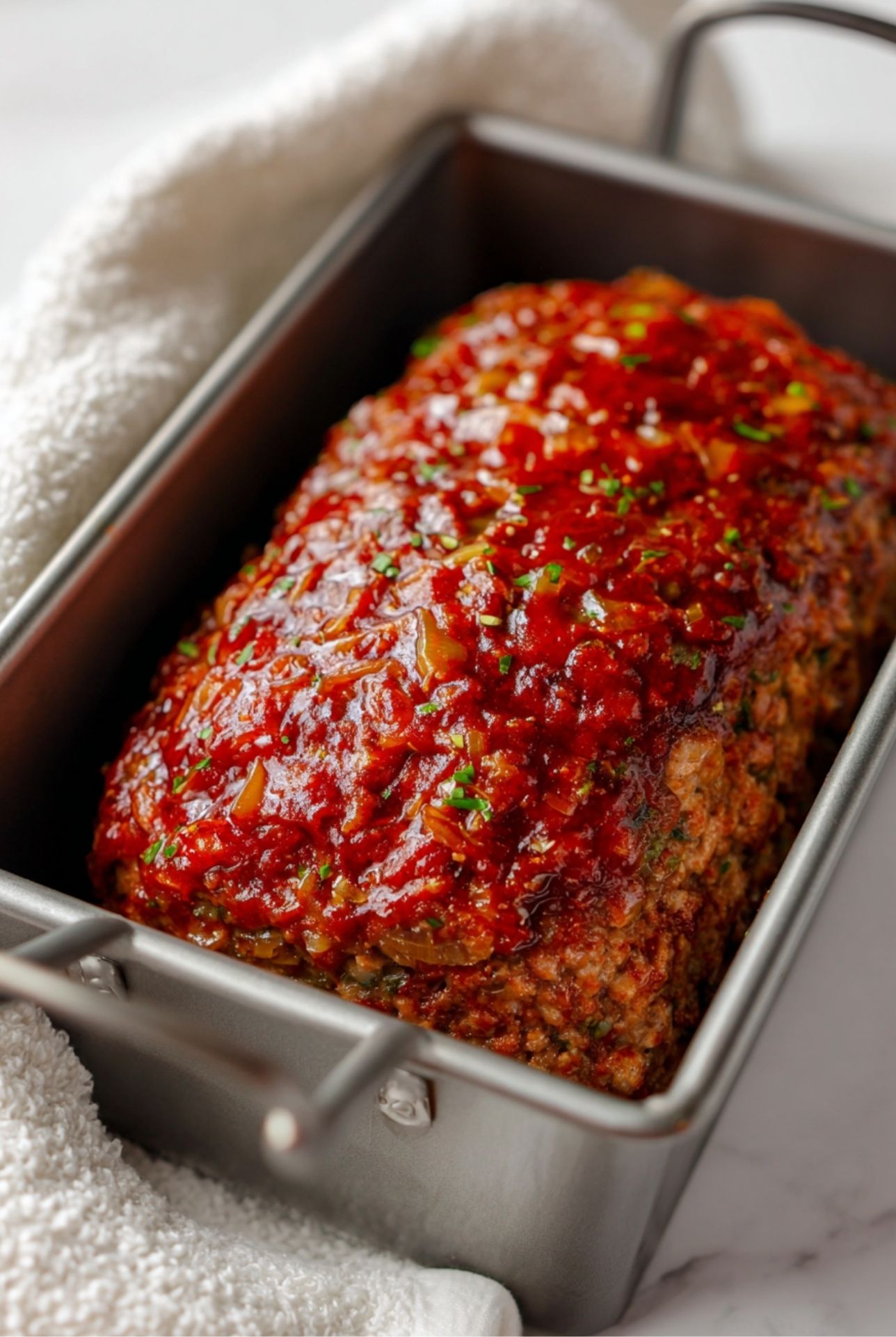 Unbaked meatloaf shaped in a loaf pan, ready for the oven with mustard glaze topping.”