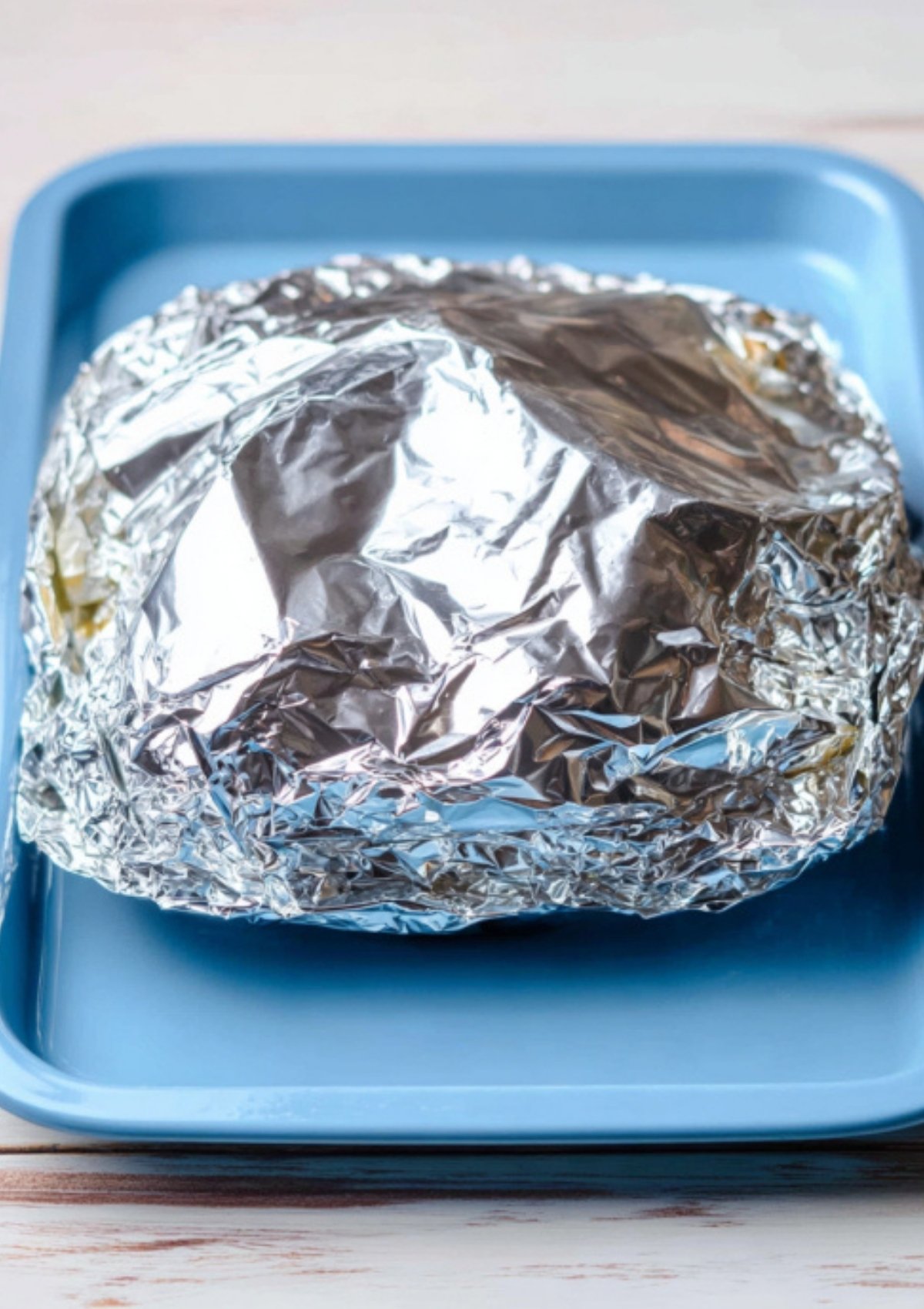 Hot baked salmon topped with golden lemon slices and garlic butter sauce resting on foil after baking.