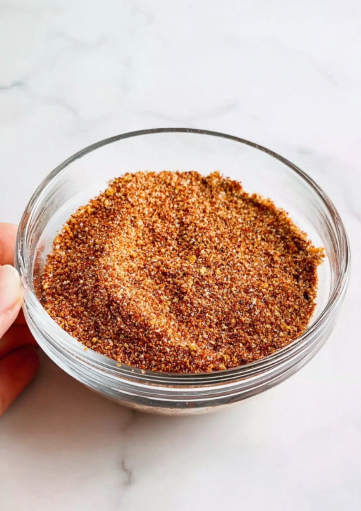 Glass bowl filled with homemade BBQ spice rub, ready to season pork for pulled pork sandwiches.