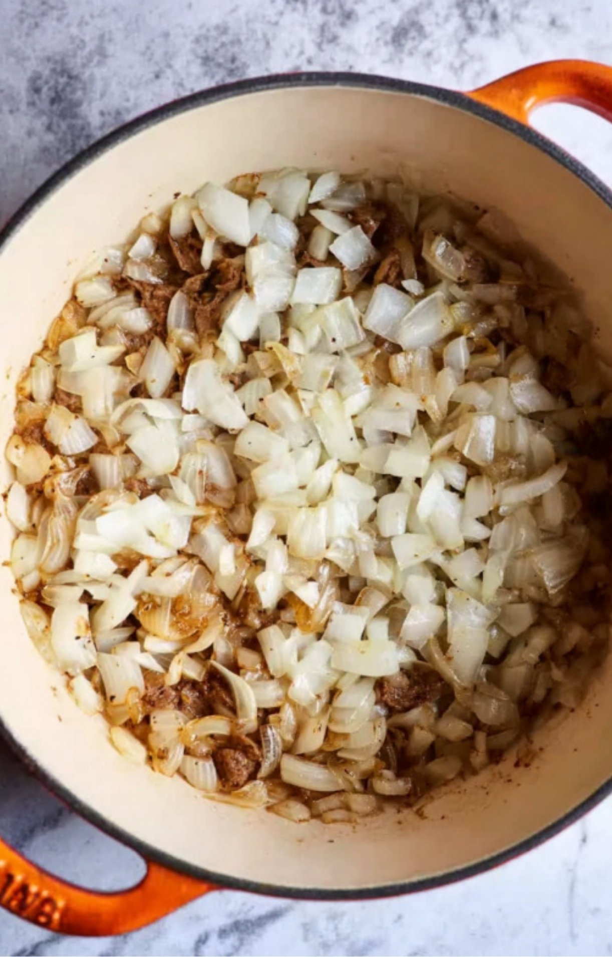 Chopped onions sautéing until golden in a pot, the first step for a rich and savory leftover roast beef stroganoff.
