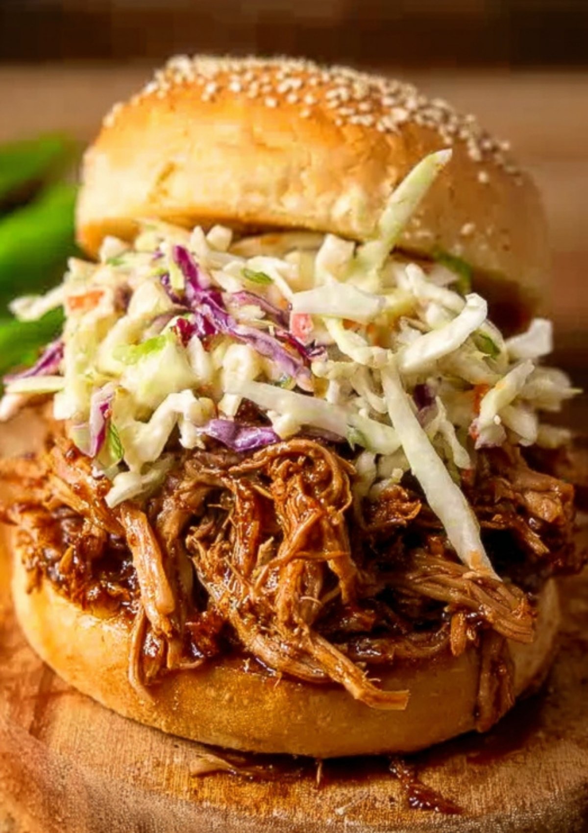 Closeup of a BBQ pulled pork sandwich topped with coleslaw, perfect for parties or weeknight dinner.