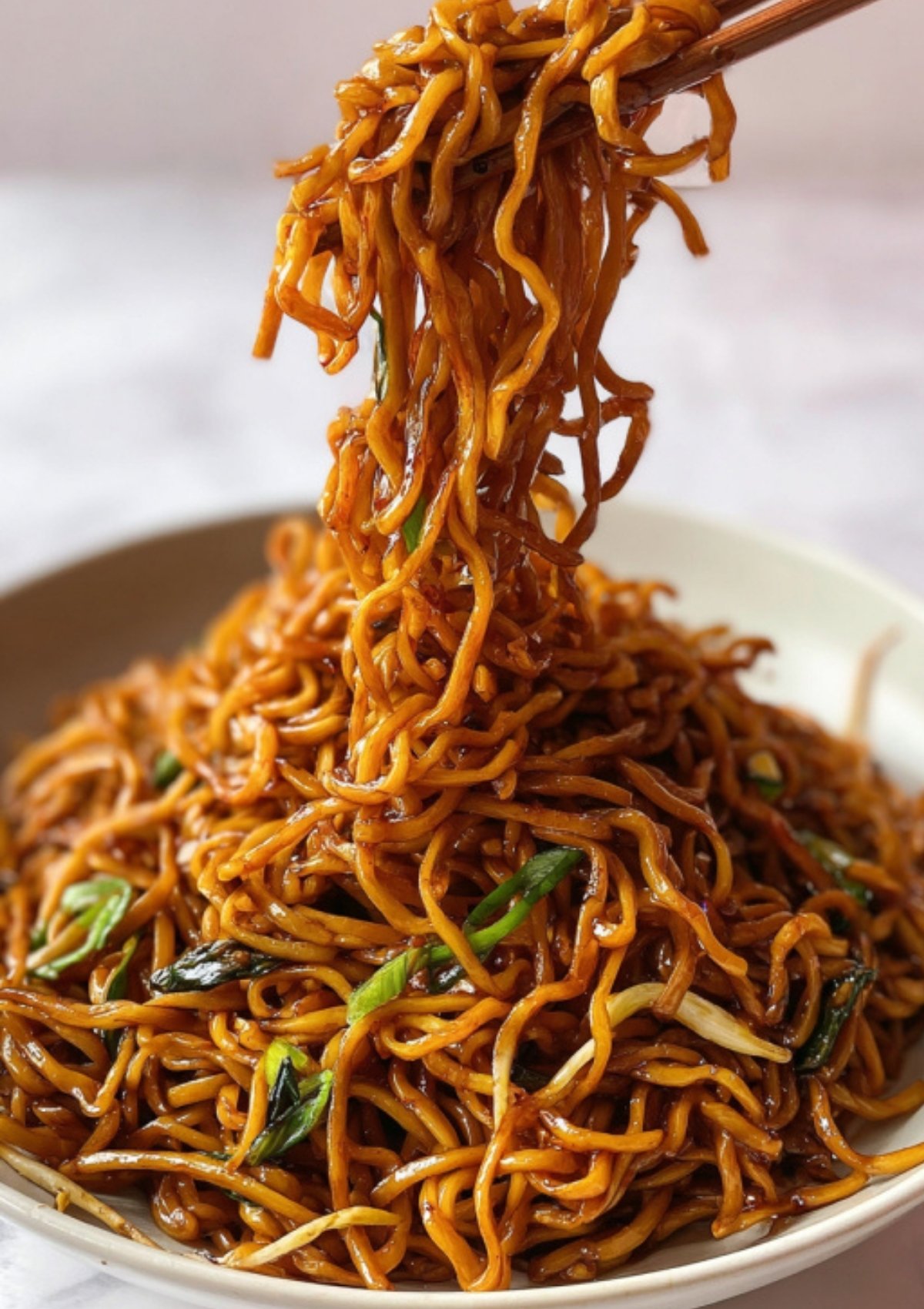 Fresh egg noodles being drained over a pot, perfect for making quick and easy soy sauce noodles at home.