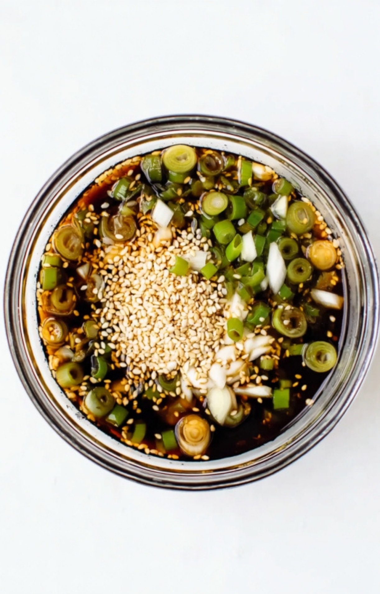 Closeup of soy sauce marinade with sesame seeds and chopped scallions