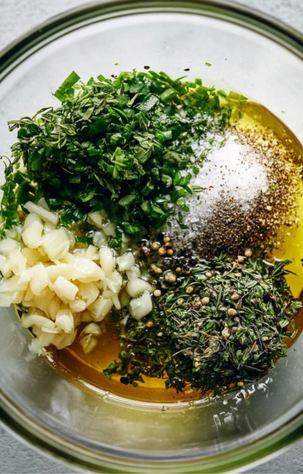 Chopped herbs, garlic, salt, and spices in olive oil, ready to rub on a beef roast