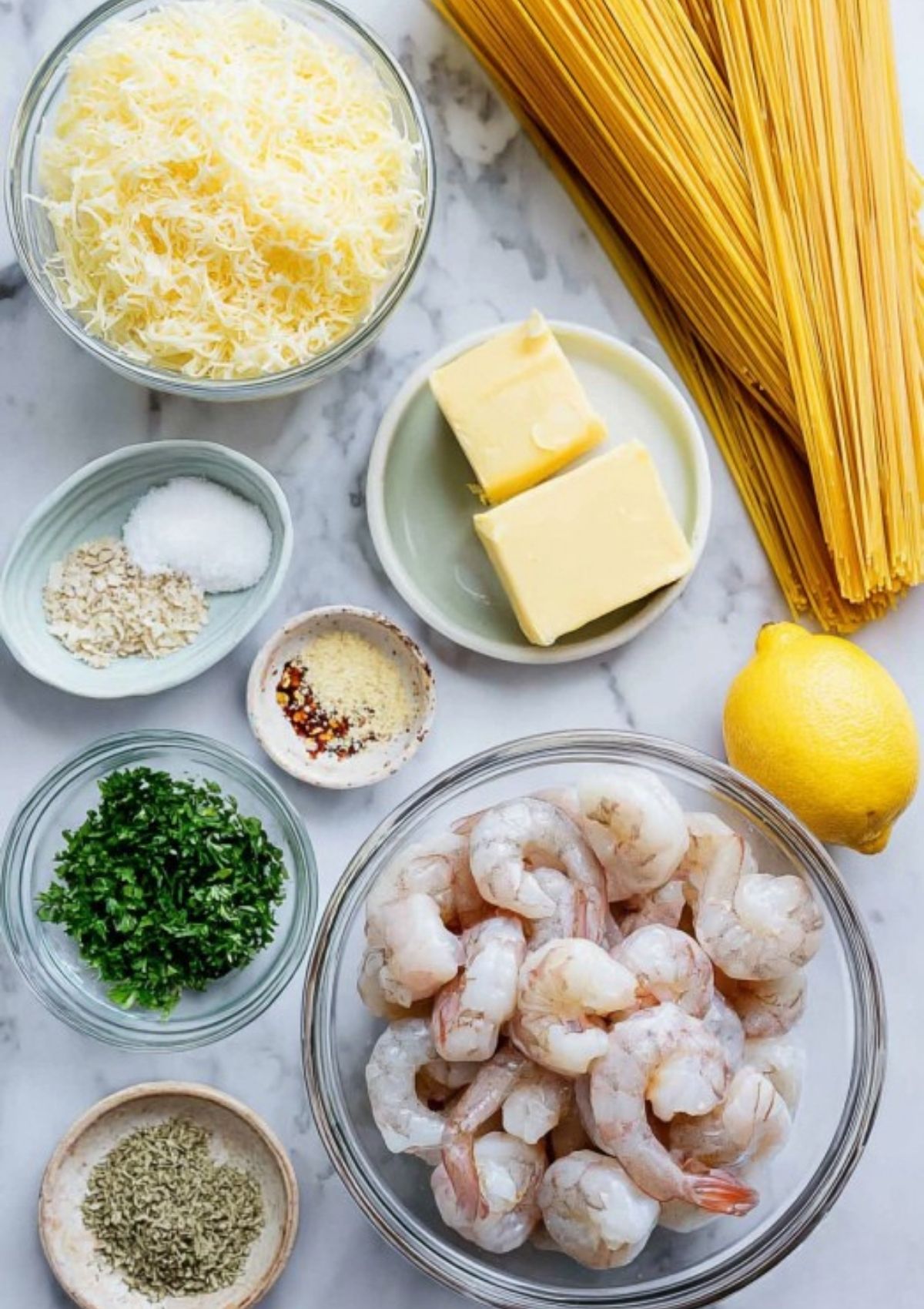 Butter, Parmesan, shrimp, lemon, garlic, and pasta ingredients for shrimp pasta recipe
