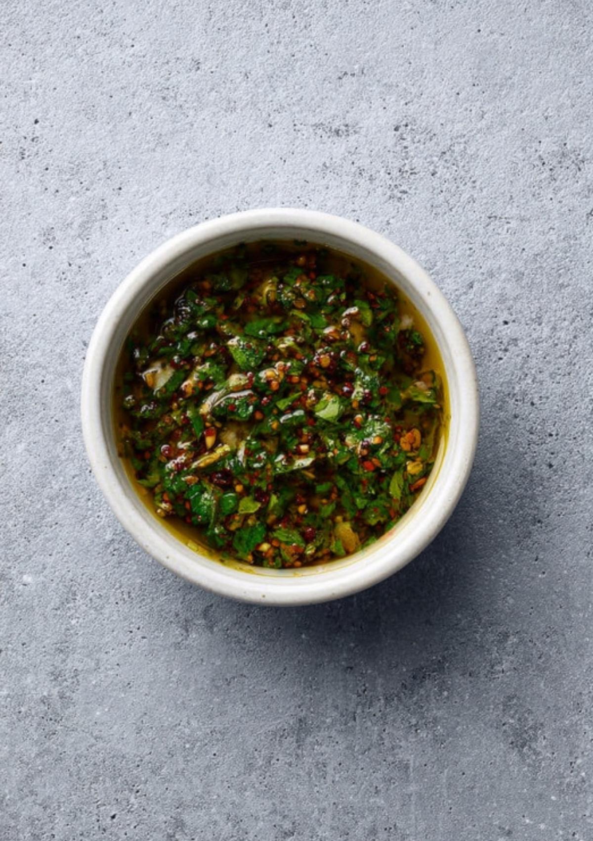 Bowl of homemade chimichurri sauce with parsley, garlic, and olive oil—perfect topping for grilled chuck roast.