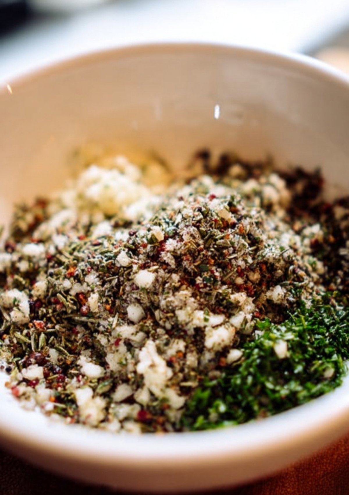 Closeup of garlic, herbs, and salt mixture in a bowl, ready to season a holiday prime rib