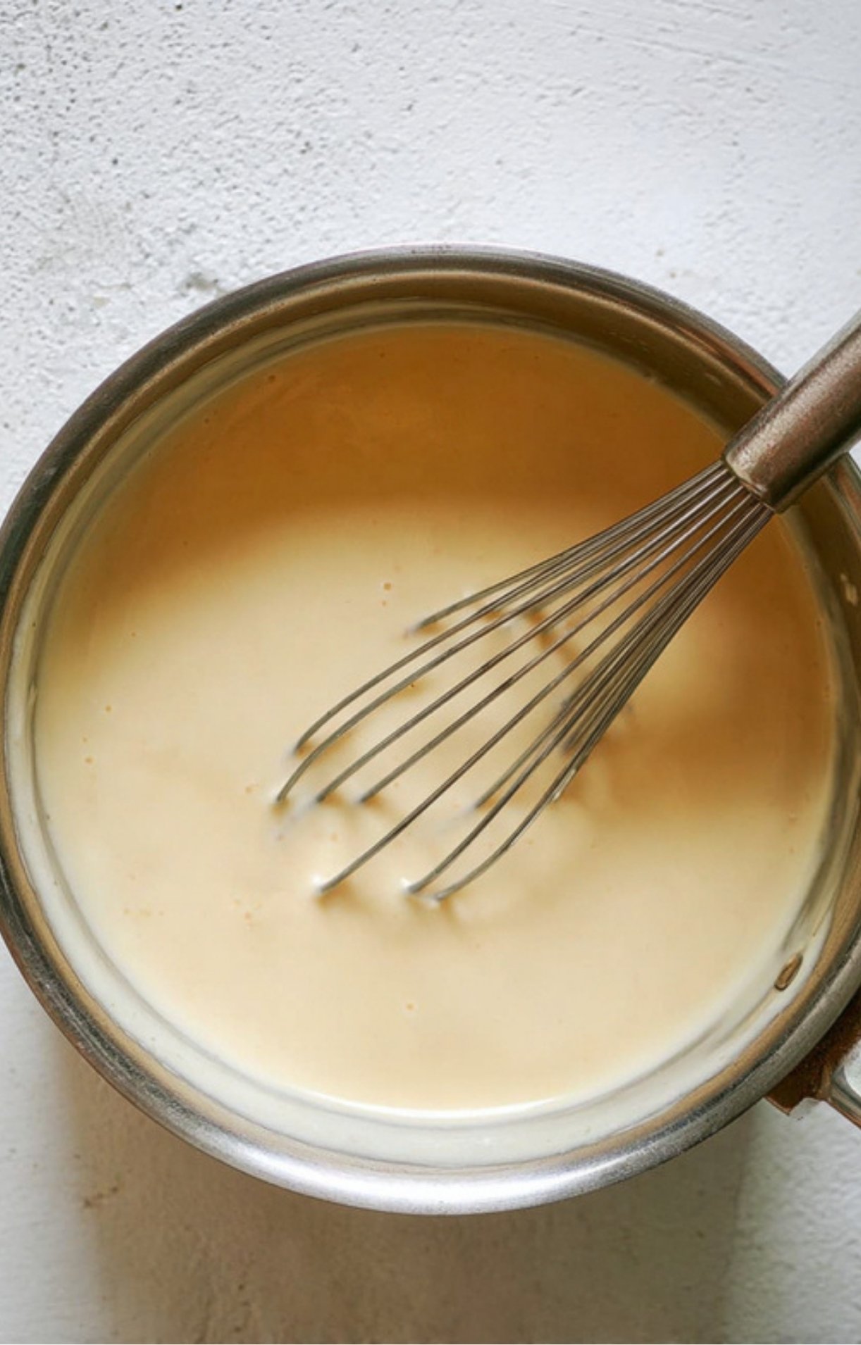 Finished creamy cheese sauce in a pot, ready to pour over sandwiches or fries