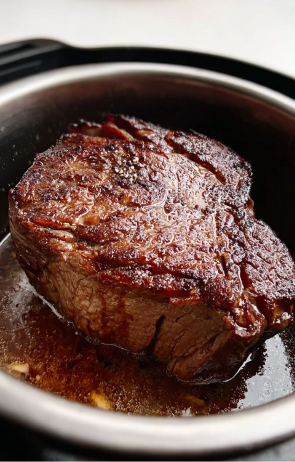 Beef chuck roast being seared in an Instant Pot until browned, step one for flavor-packed Mississippi Pot Roast.