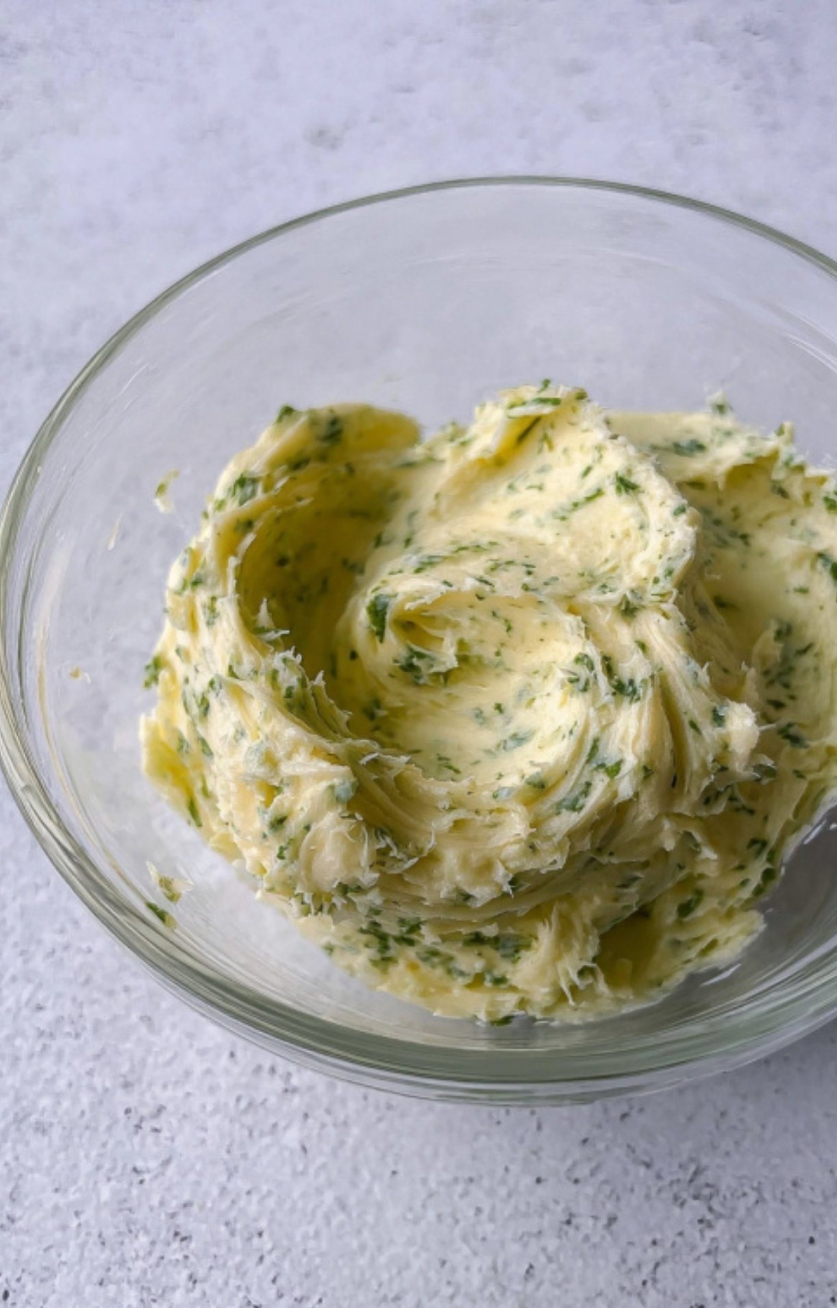 Bowl of homemade herb garlic butter ready to spread on beef roast.