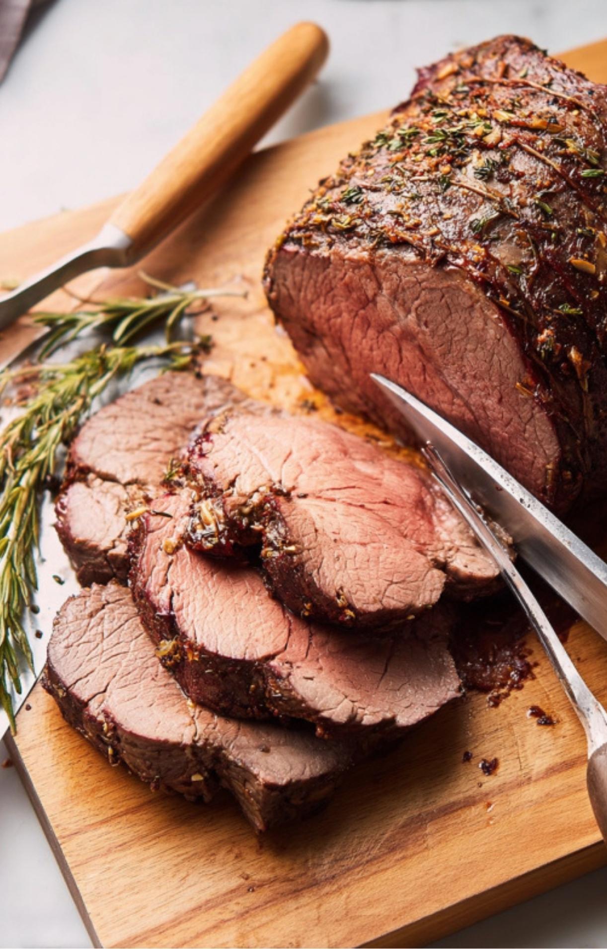 Carving juicy roast beef topped with fresh rosemary and thyme, ideal for entertaining, family gatherings, and meal prep.