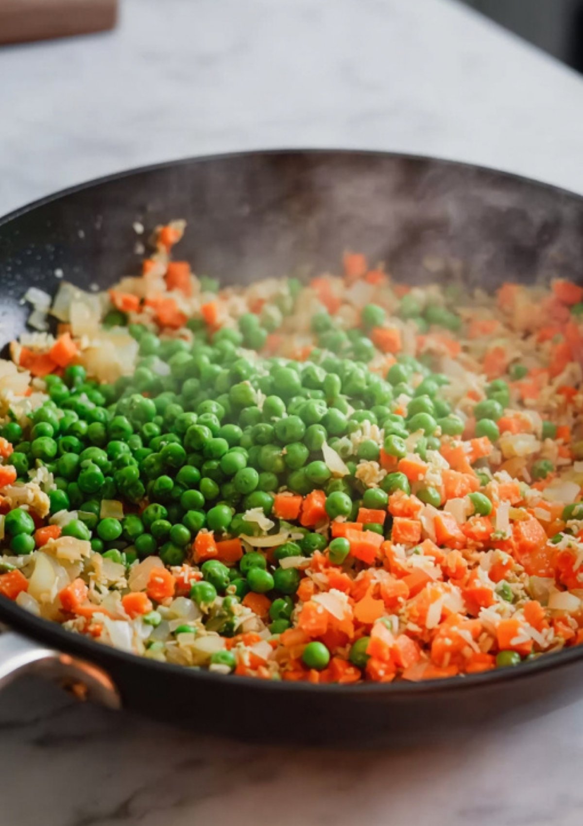 Sautéed carrots, onions, and peas in a hot skillet as the first step to healthy chicken fried rice.