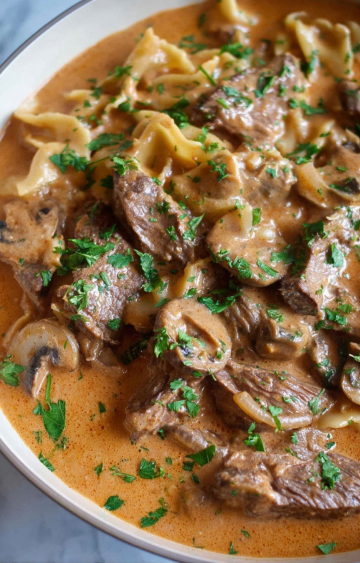 Leftover roast beef stroganoff served over egg noodles with mushrooms and fresh parsley, comfort food for cozy weeknights.