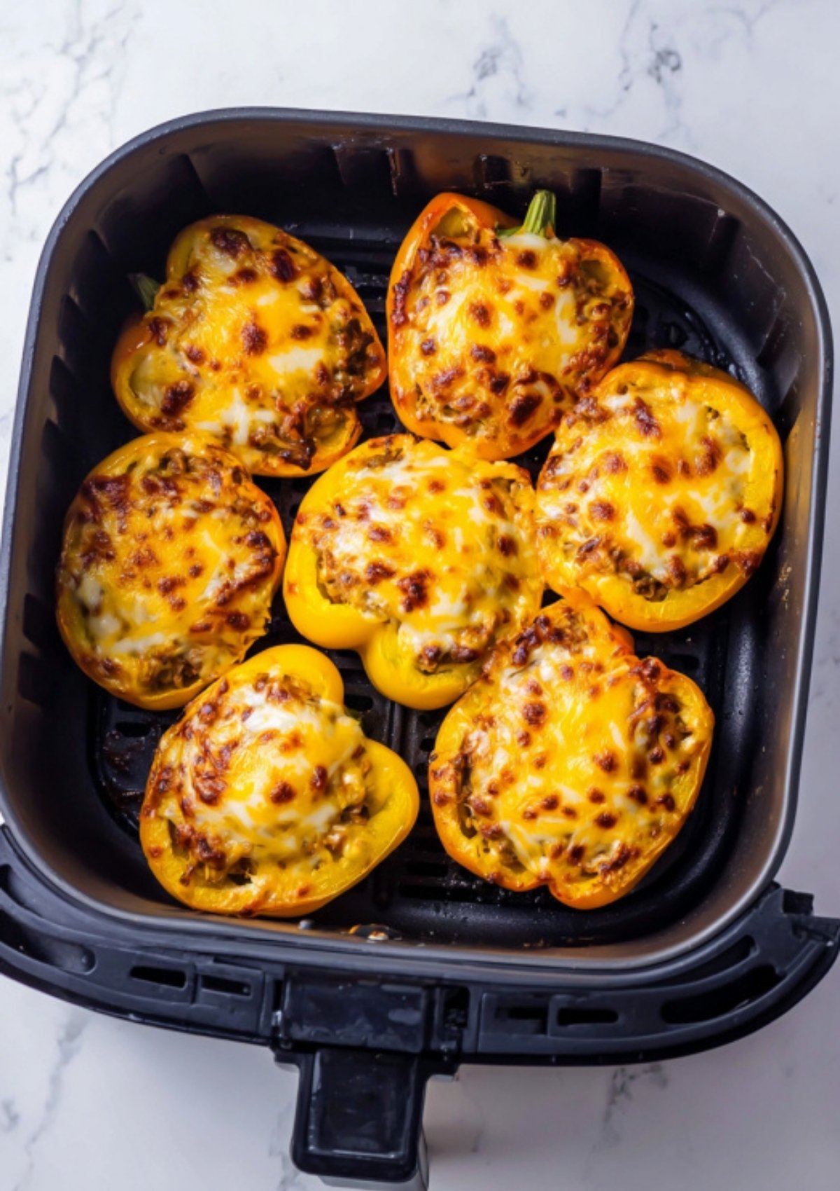 Stuffed bell peppers topped with melted cheddar cheese cooked in the air fryer