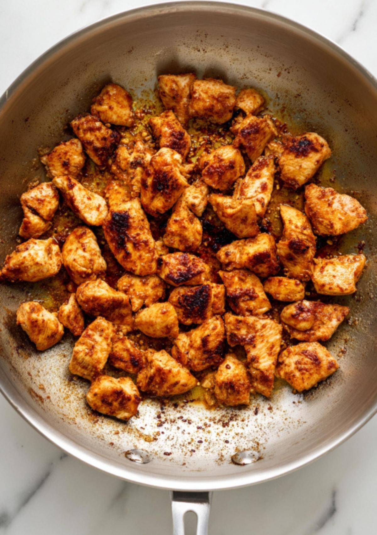 Golden, bite-sized chicken pieces sautéed in a stainless steel skillet—ideal base for fajita pasta, tacos, or meal prep.