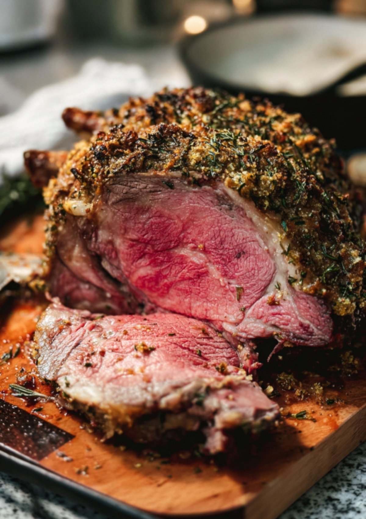 Sliced prime rib roast with a golden herb crust on a cutting board, showing a perfectly pink and juicy center, classic holiday beef recipe