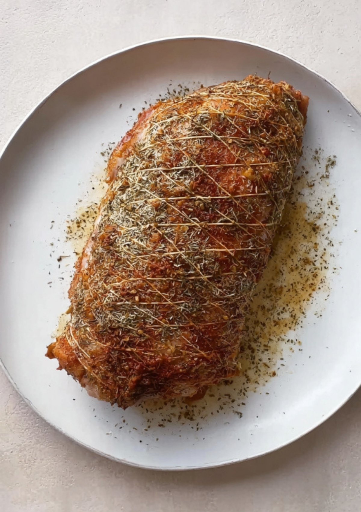 Whole Butterball turkey breast roast with a golden herb crust resting on a plate.
