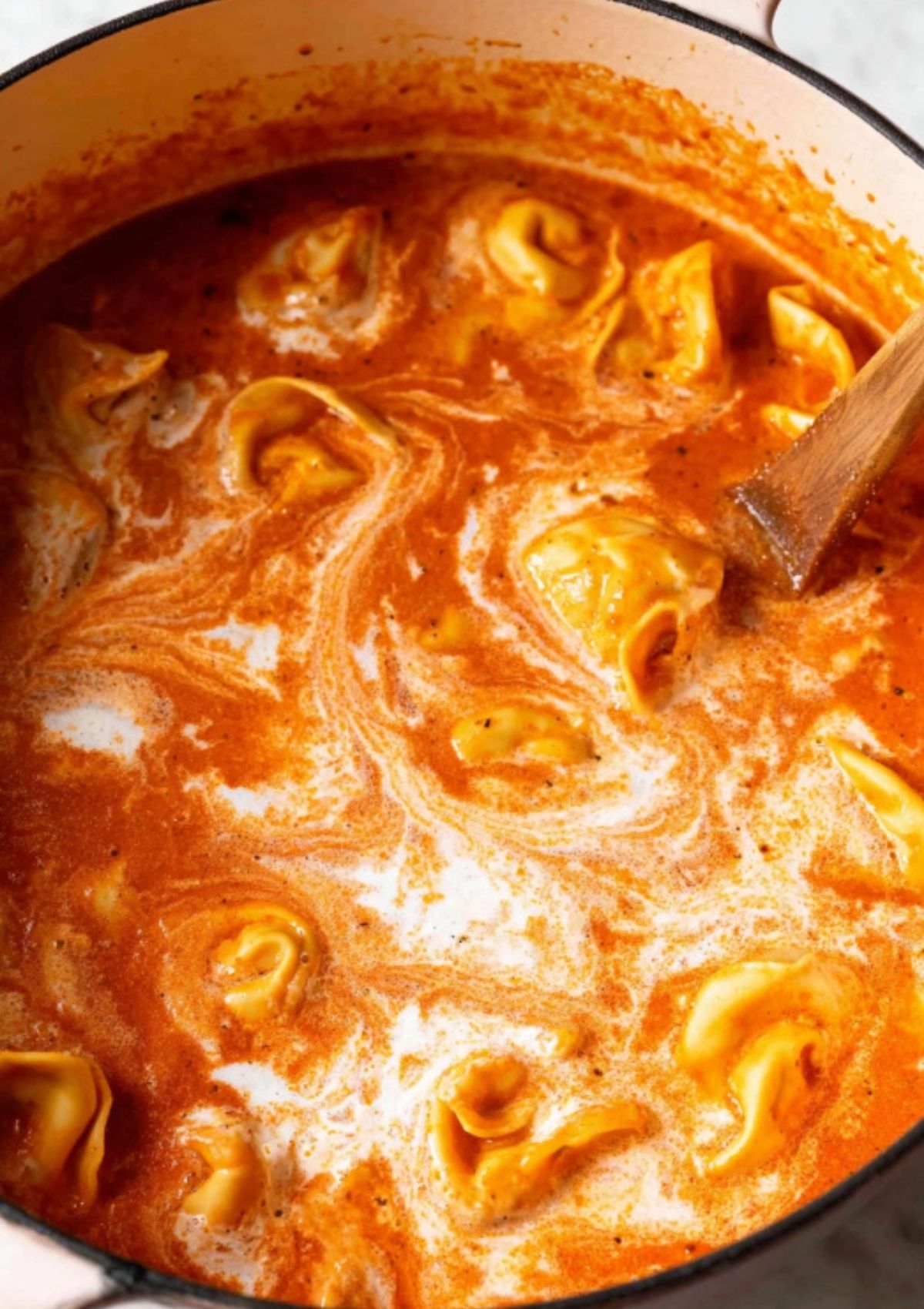 Creamy tomato soup with cheese tortellini swirled in, topped with fresh herbs and parmesan.