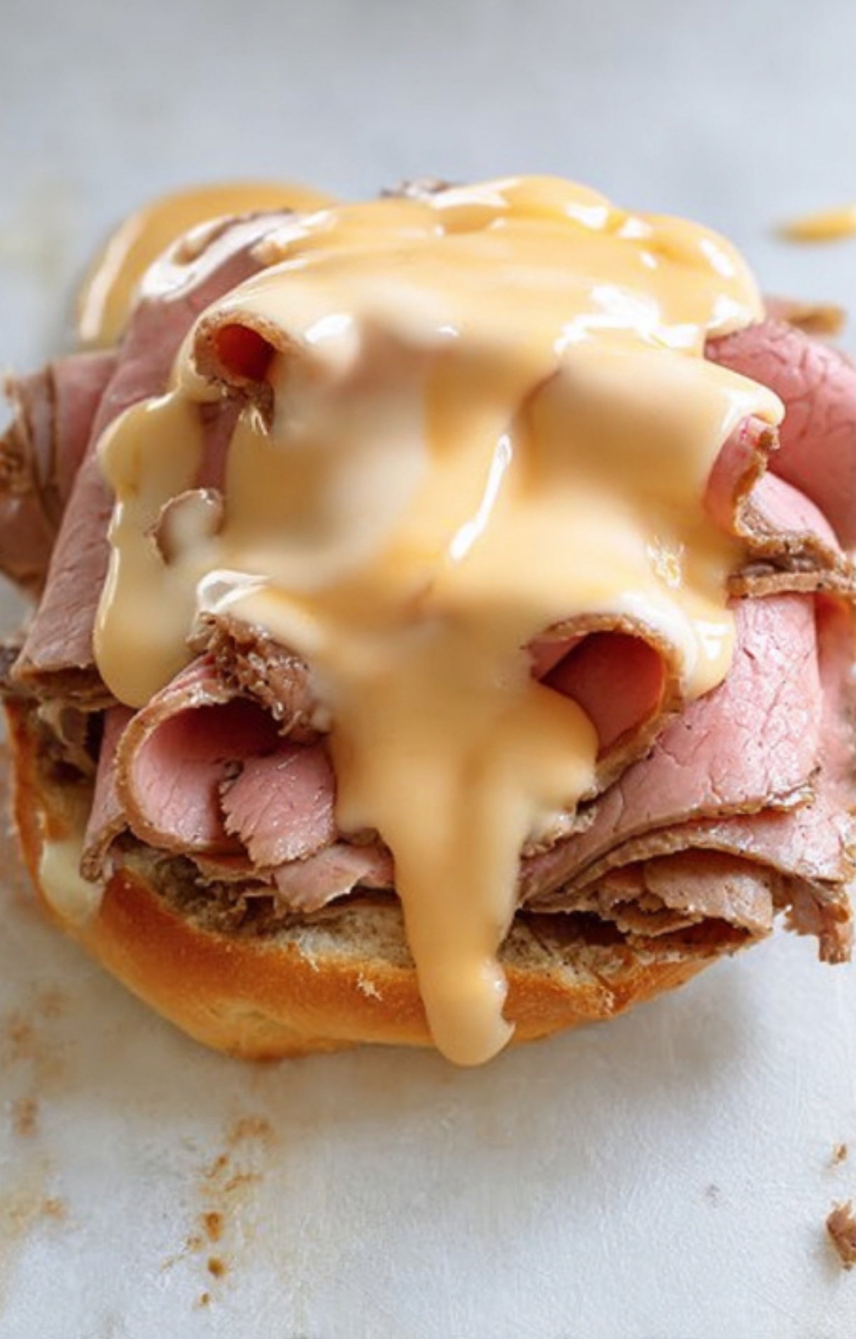 Open sandwich stacked with roast beef slices and rich cheddar cheese sauce poured on top