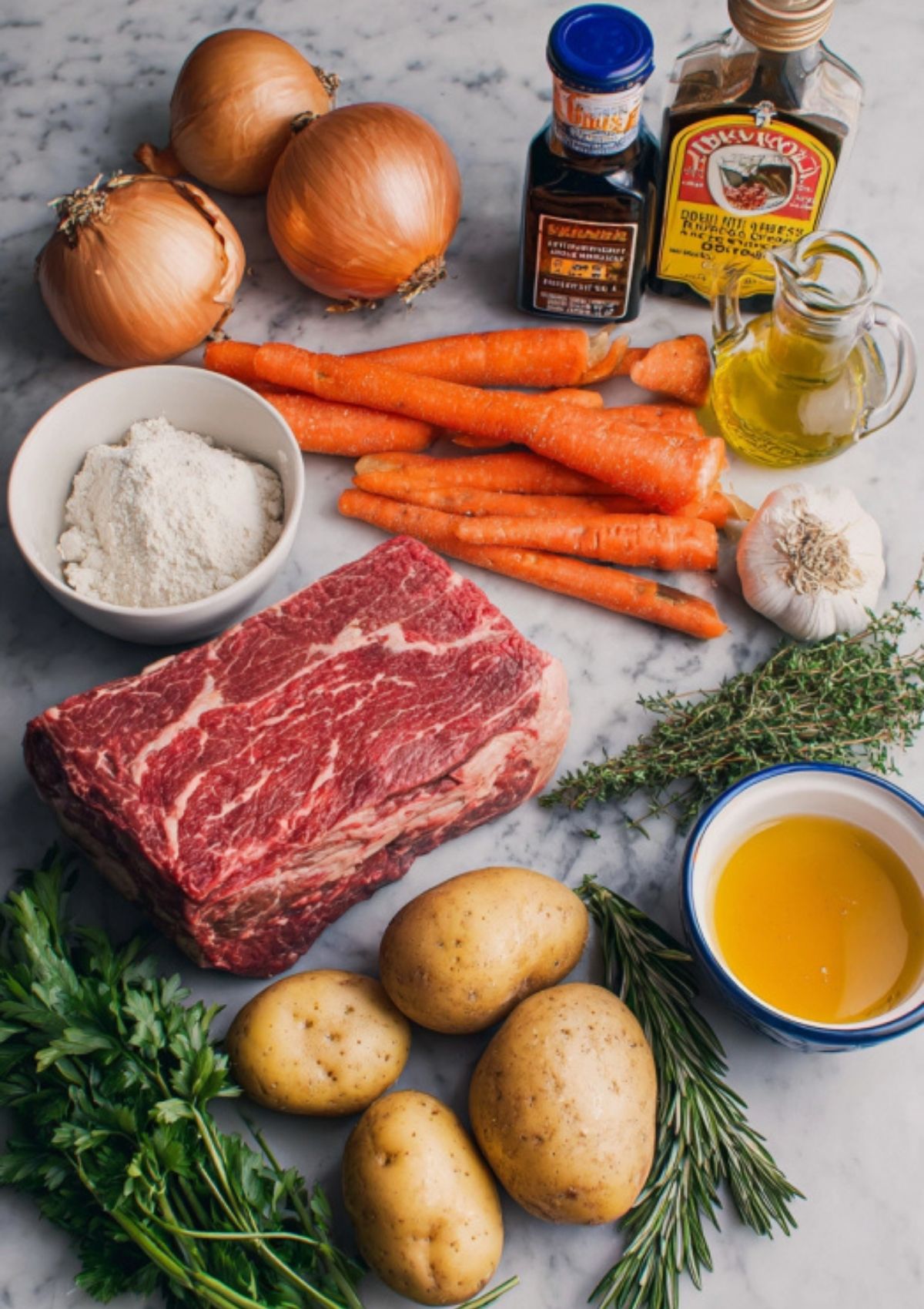 Raw chuck roast, Yukon gold potatoes, carrots, onions, fresh herbs, olive oil, beef broth, and Worcestershire sauce arranged on a marble counter.