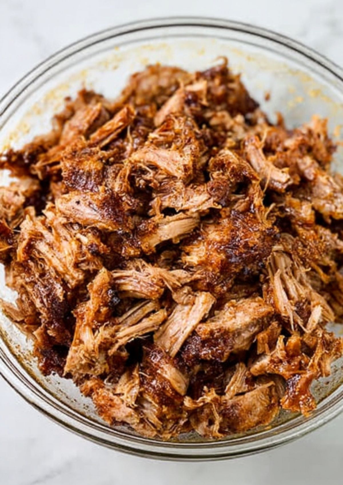 Bowl of juicy shredded BBQ pulled pork, perfect for sandwiches, tacos, or meal prep.