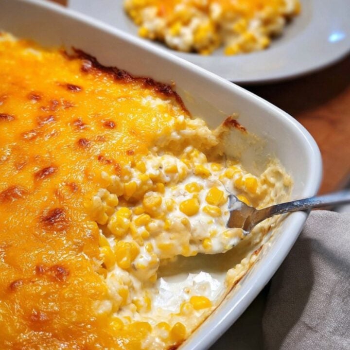 Golden, bubbly baked cream cheese corn casserole being scooped from a baking dish, perfect for Thanksgiving, Christmas, or any comfort food occasion.