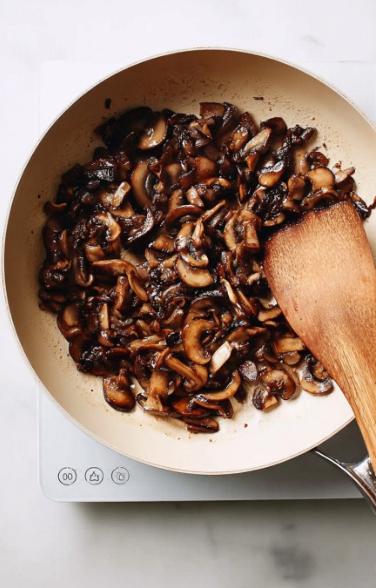 Sliced mushrooms being sautéed in a skillet for the perfect mushroom duxelles, a key layer in classic individual beef wellington. Great for holiday meals and dinner parties.