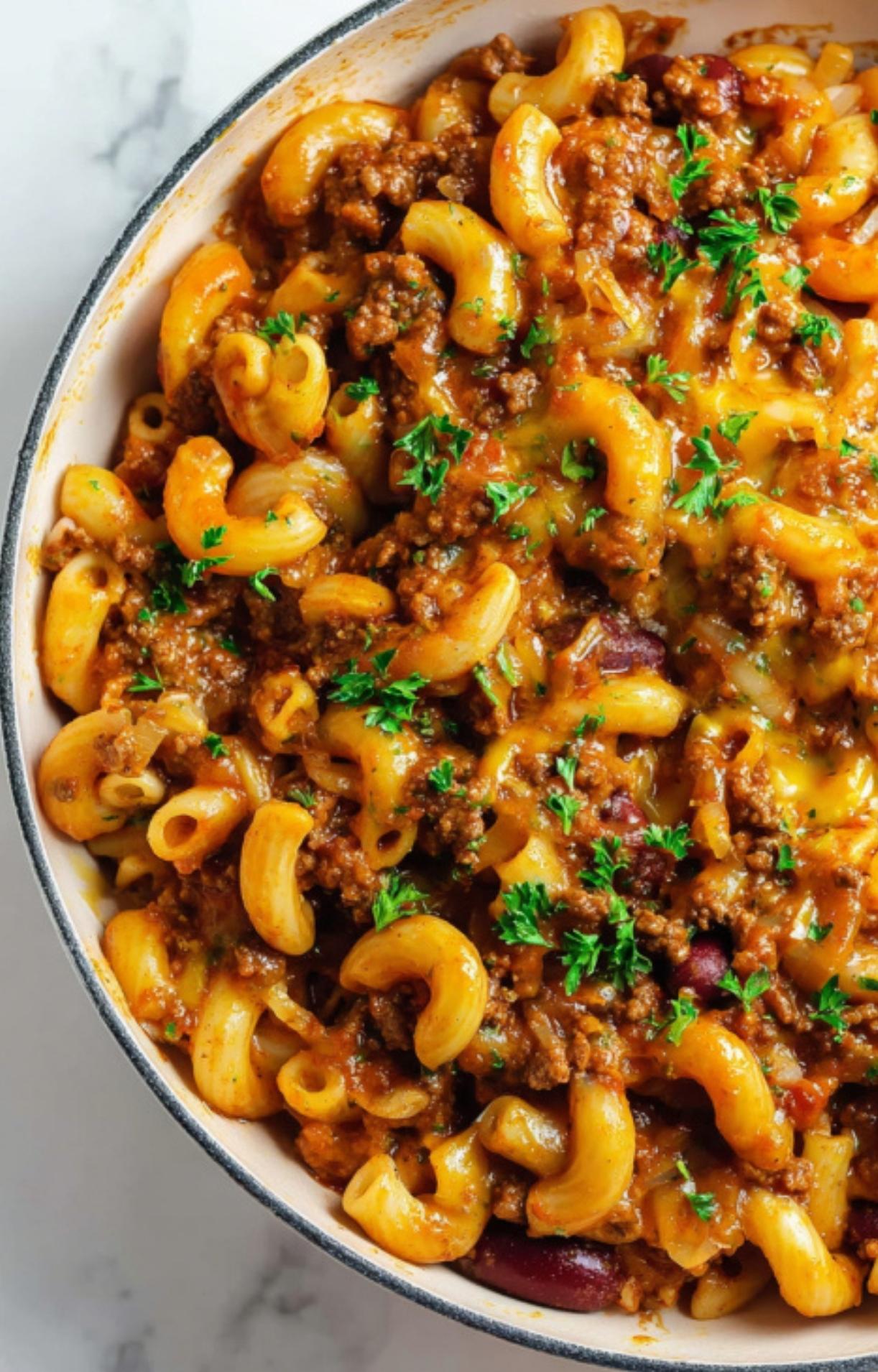 Large pot filled with cheesy ground beef goulash, elbow macaroni, tomatoes, and fresh parsley. Warm and hearty, perfect for family dinner or easy weeknight meals.