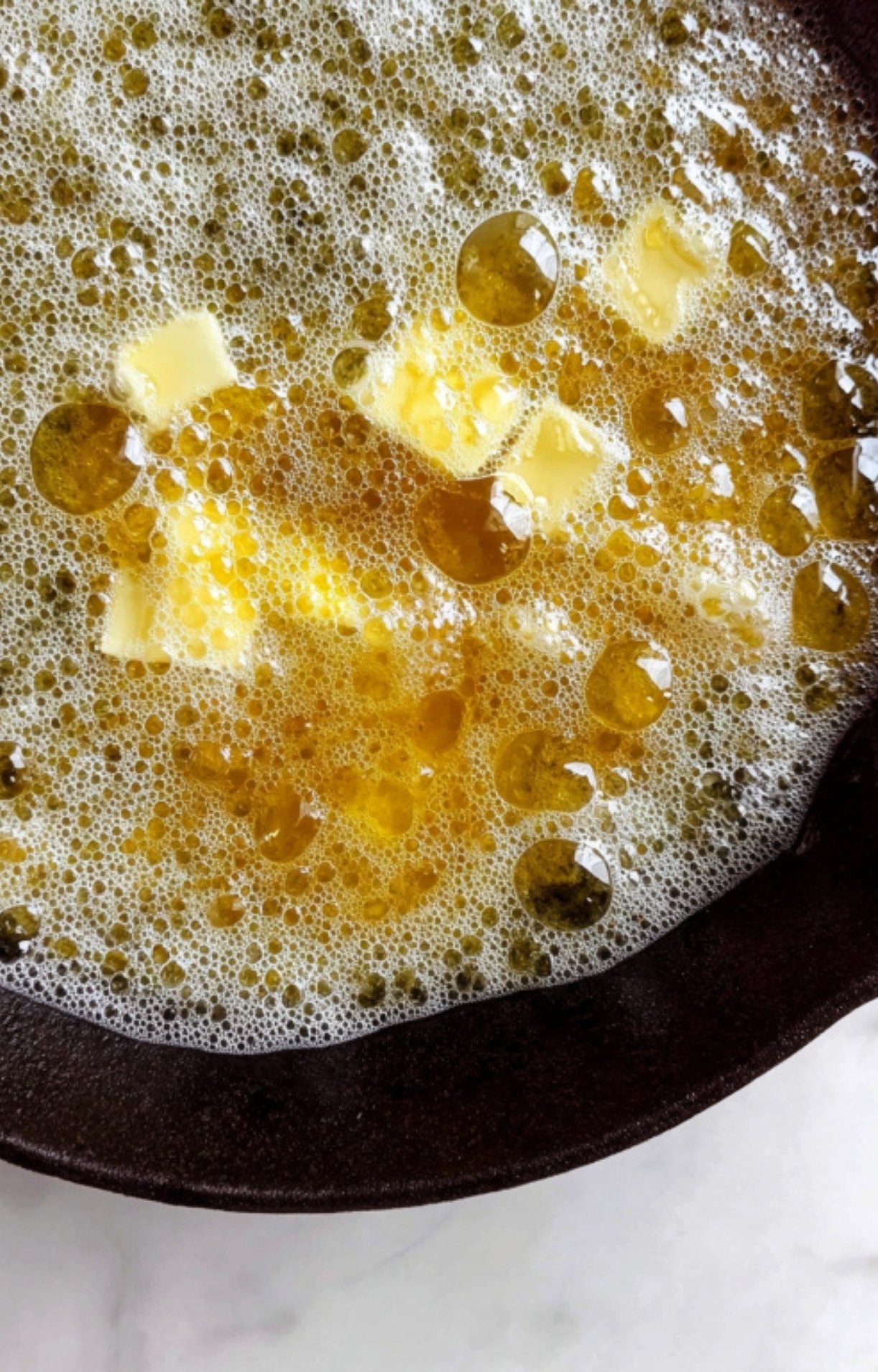 Butter and olive oil bubbling together in a hot skillet, ready for searing steak.