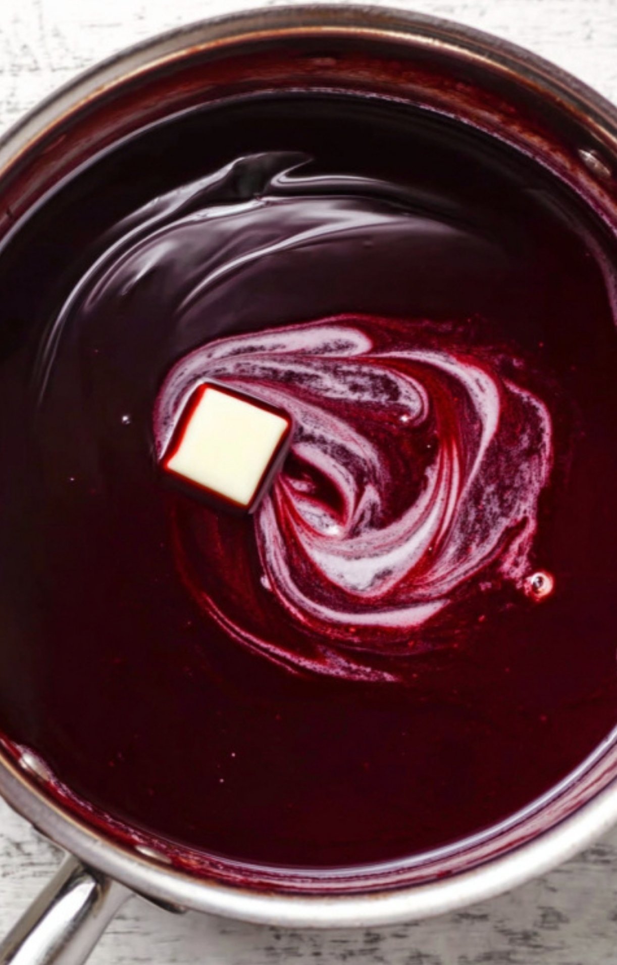 Rich red wine sauce in a saucepan, finished with a pat of butter for shine, the perfect match for beef wellington and festive meals.