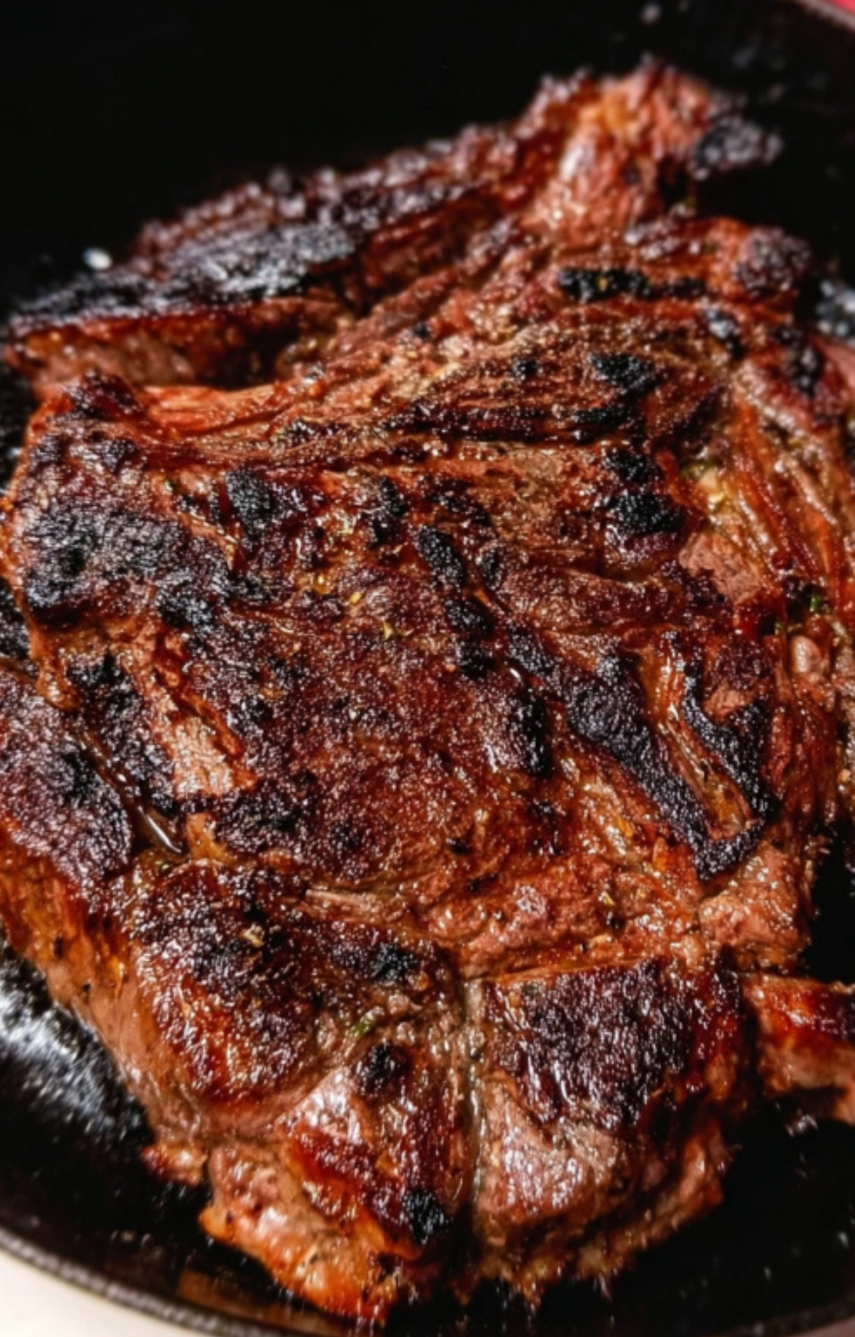 Juicy chuck steak getting a golden sear in a hot cast iron skillet for an easy steakhouse dinner at home