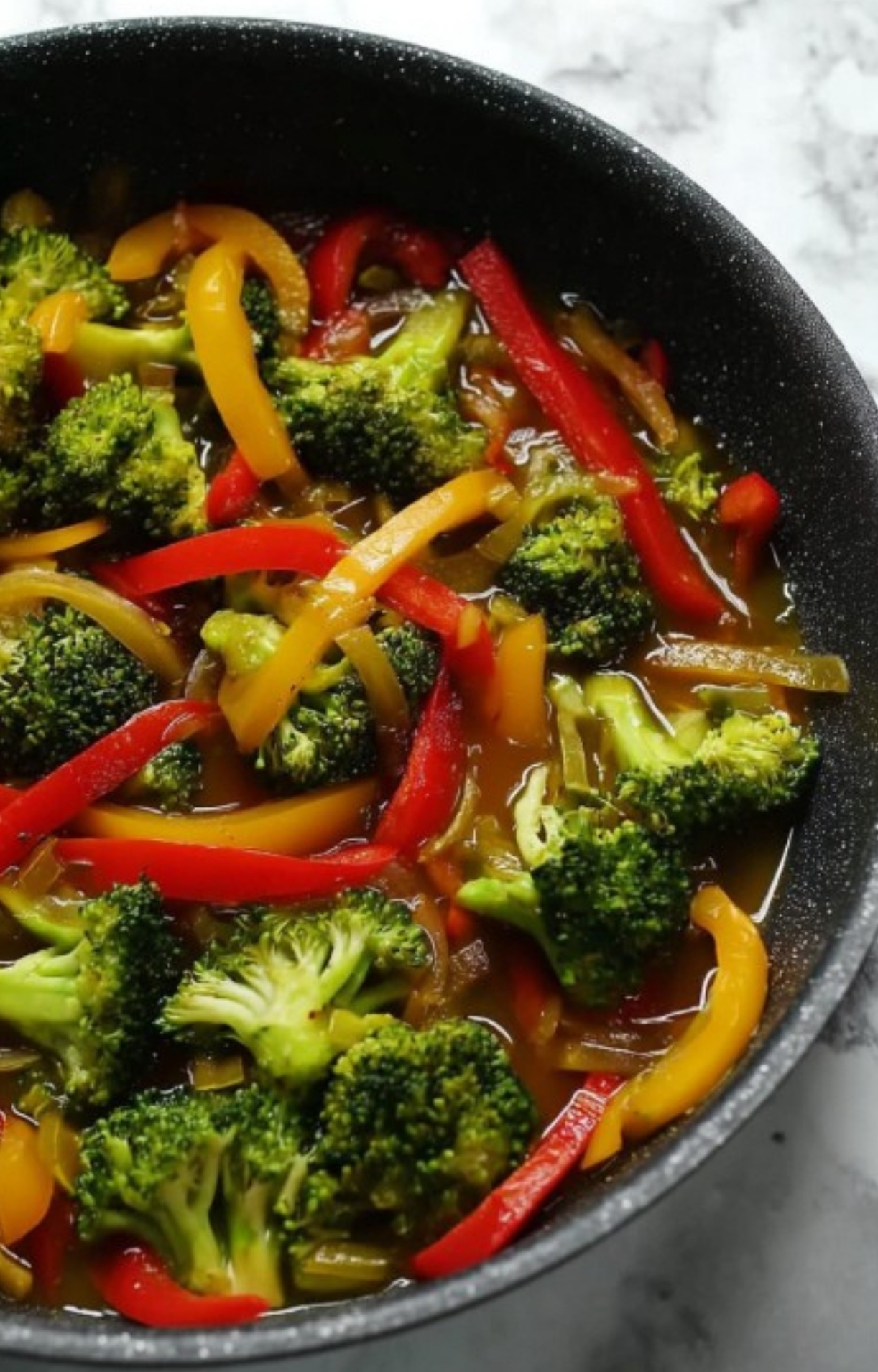 Sautéed broccoli, red and yellow bell peppers in a skillet with stir-fry sauce – simple healthy vegetable dinner