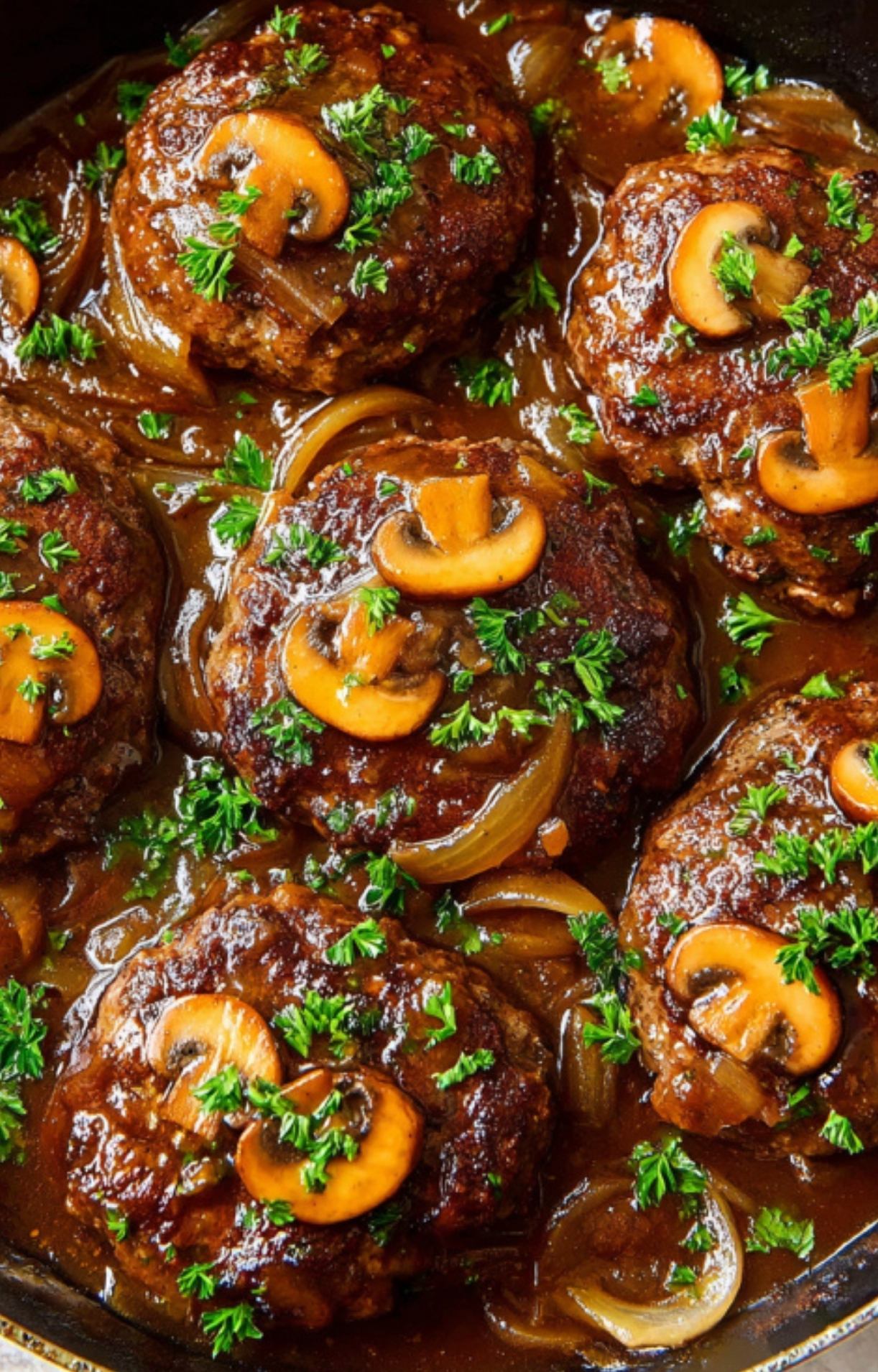 Juicy Salisbury steak patties cooking in a skillet with mushroom and onion gravy, perfect for a hearty family dinner.