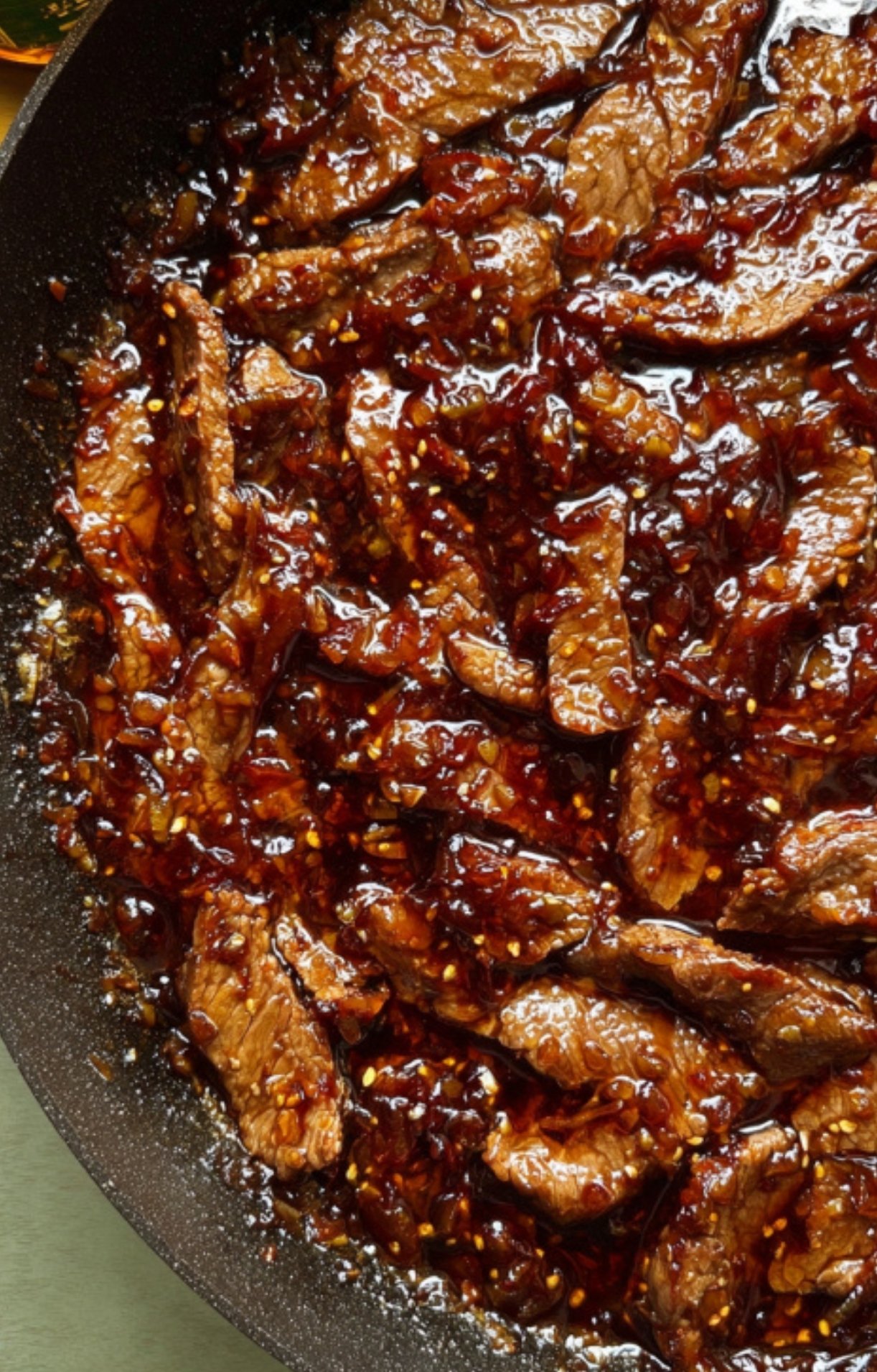 Shaved beef simmering in glossy, flavorful stir fry sauce, ready for broccoli and rice in this easy one pan meal.
