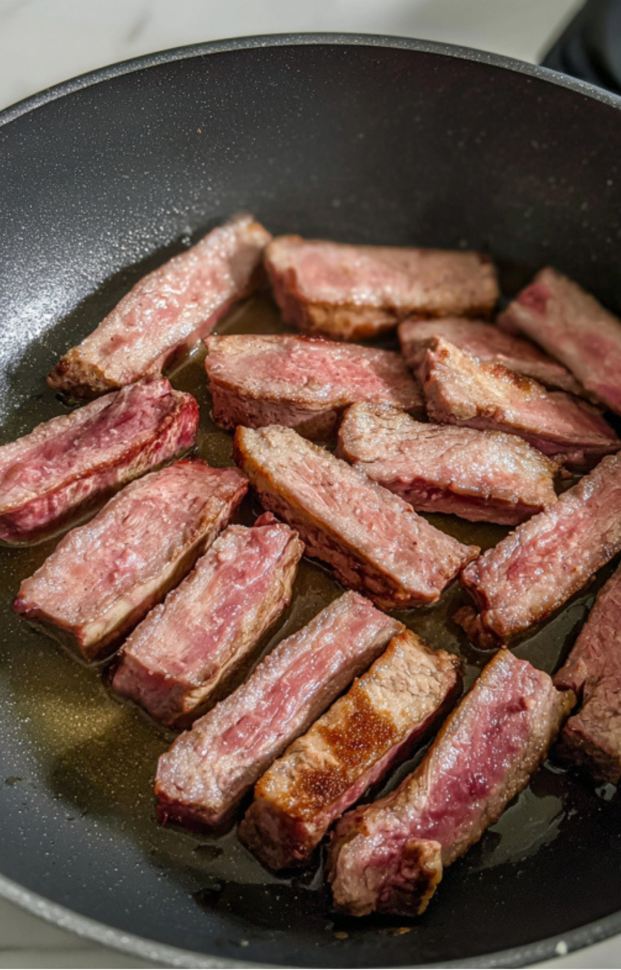 Slices of shaved steak sizzling in a hot skillet, showing the perfect sear for juicy steak tacos, easy weeknight dinners, and taco night favorites.