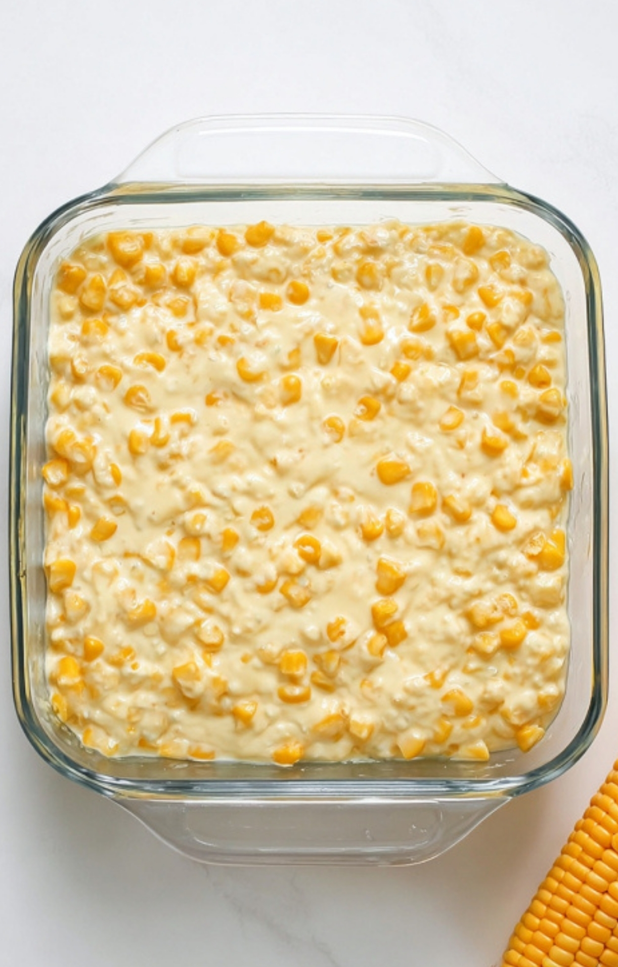 Glass baking dish filled with creamy corn casserole mixture before baking, showing an easy homemade side dish perfect for cozy dinners and family gatherings.