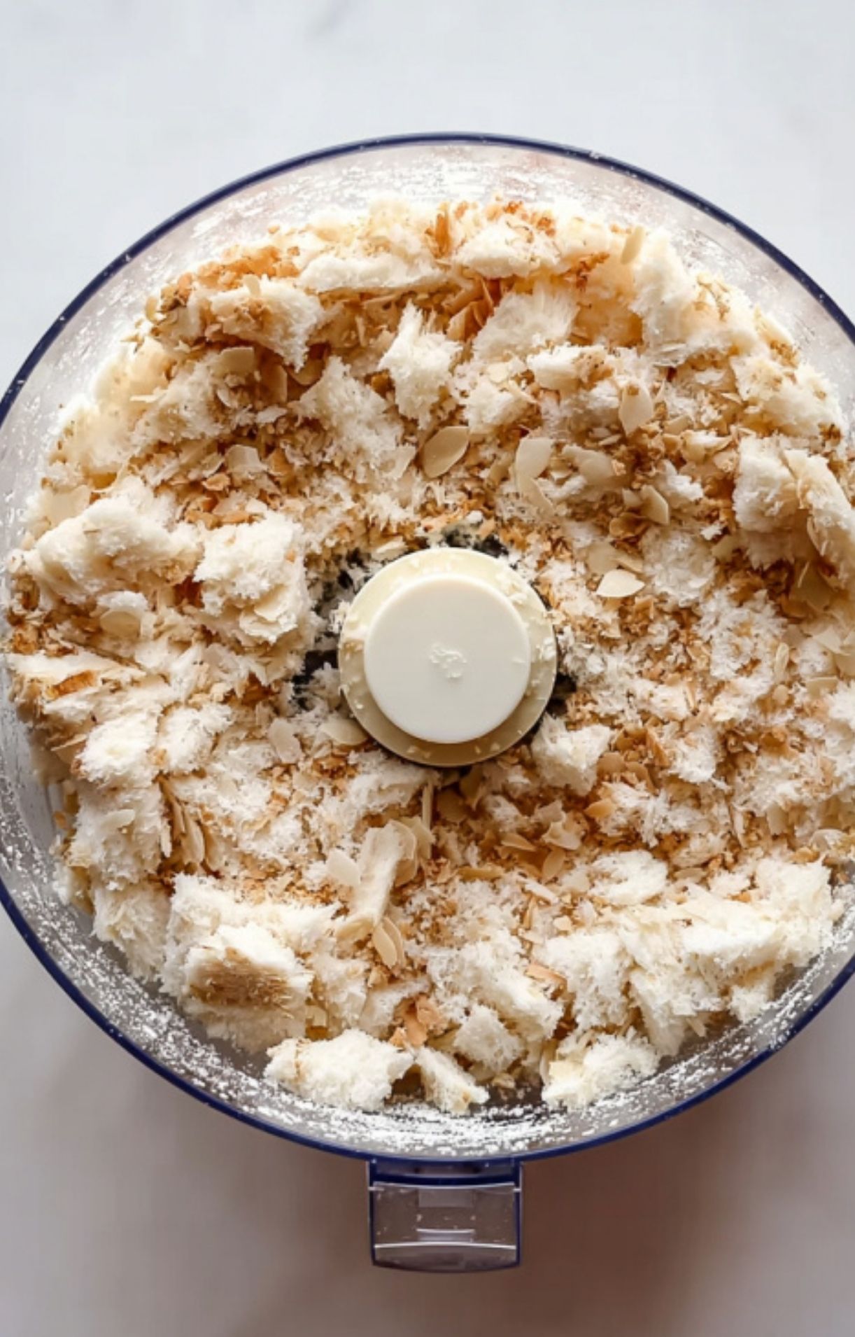 Step-by-step making of a breadcrumb and almond topping in a food processor for traditional cassolette recipe, easy French comfort food for family dinners and holiday gatherings.