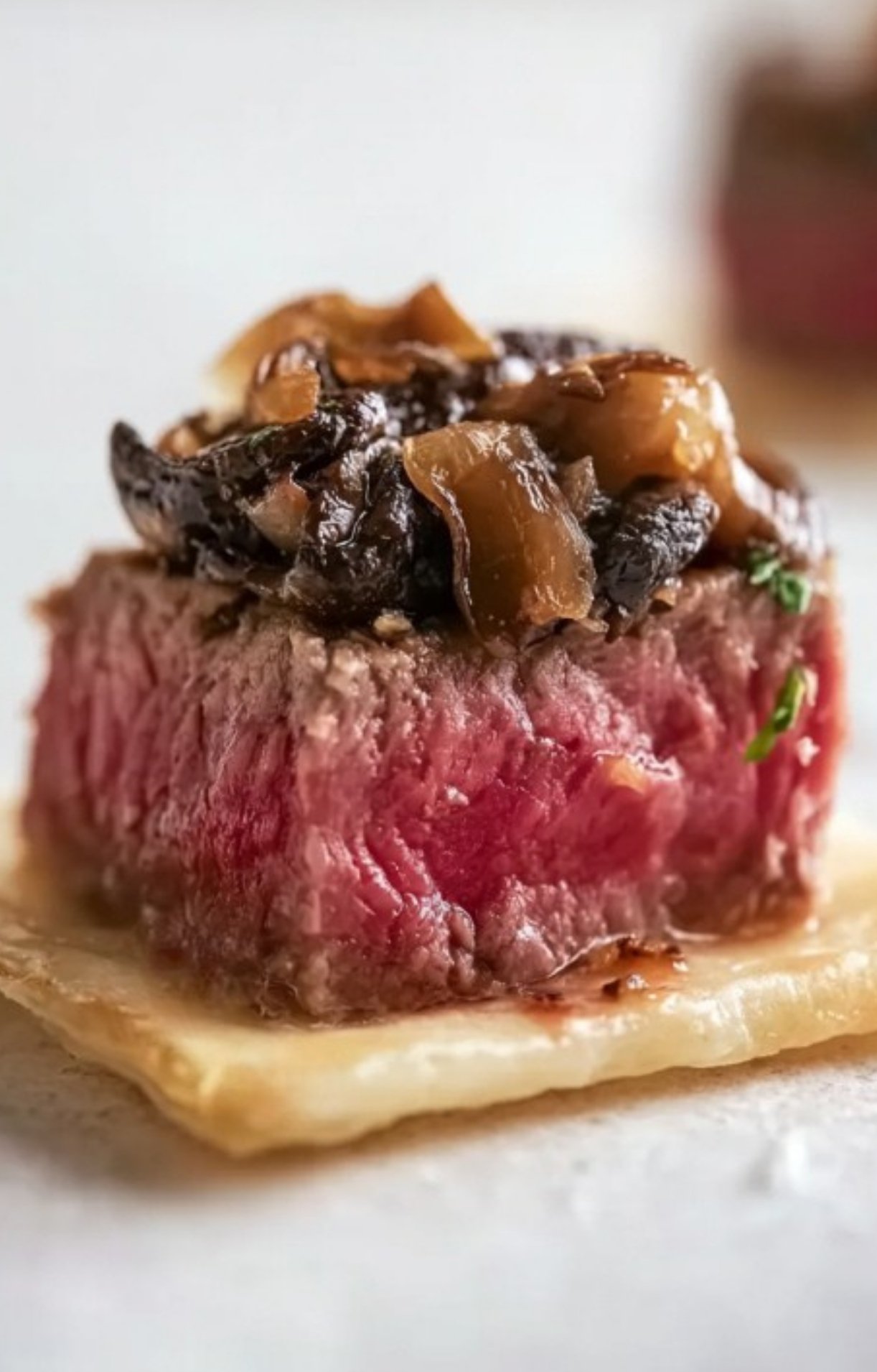 Close-up of a single Mini Beef Wellington bite with seared beef, mushrooms, and flaky puff pastry, great for festive celebrations and easy party snacks.