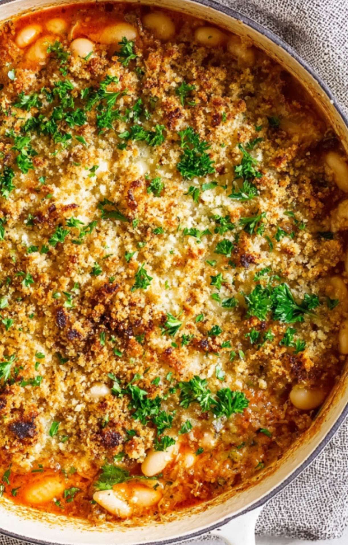 Cassoulet fresh from the oven with a golden, crispy breadcrumb topping and parsley, perfect for cozy winter meals.