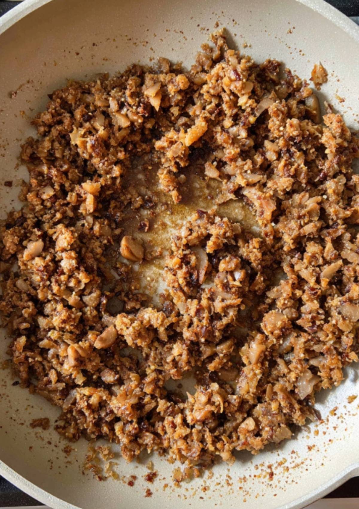 Chopped mushrooms, onions, and herbs sautéing in a pan to make the flavor-packed mushroom duxelles for individual beef wellington. Great for holiday appetizers, dinner parties, and family meals.