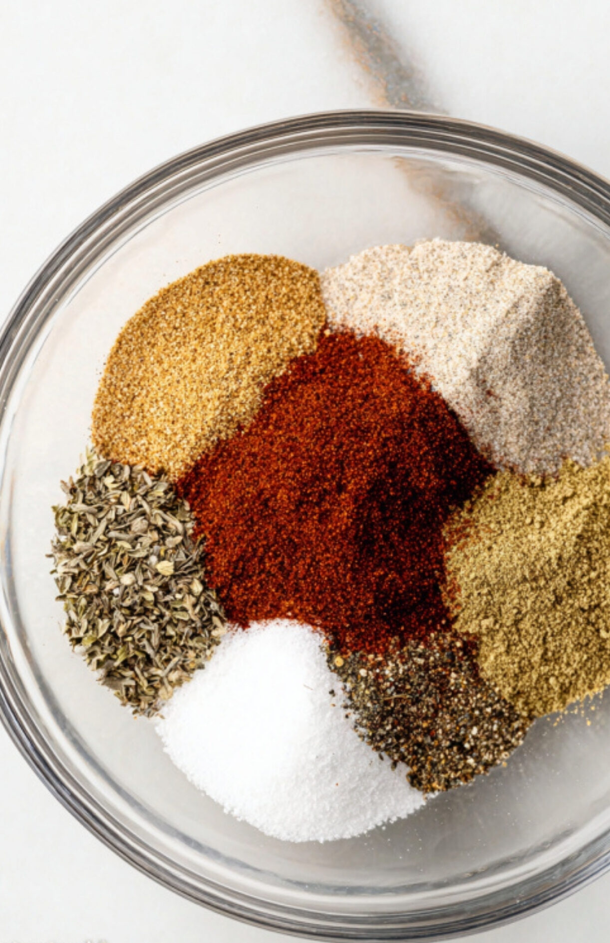 A bowl of colorful dry rub spices including paprika, garlic, onion powder, and herbs, the perfect blend for smoked steak recipes.