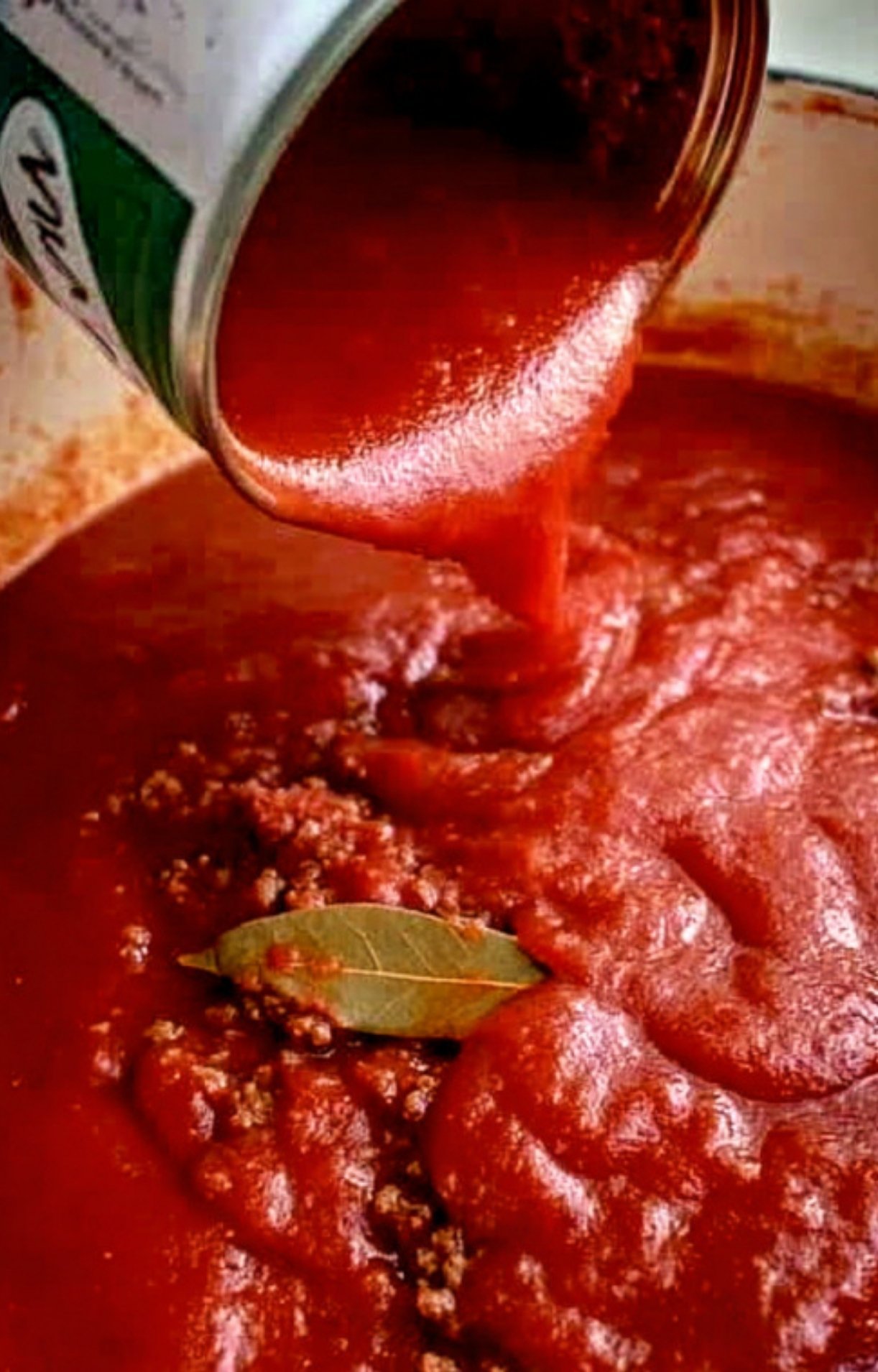 Ground beef and onions browning together with bay leaves for a homemade goulash recipe, step-by-step.