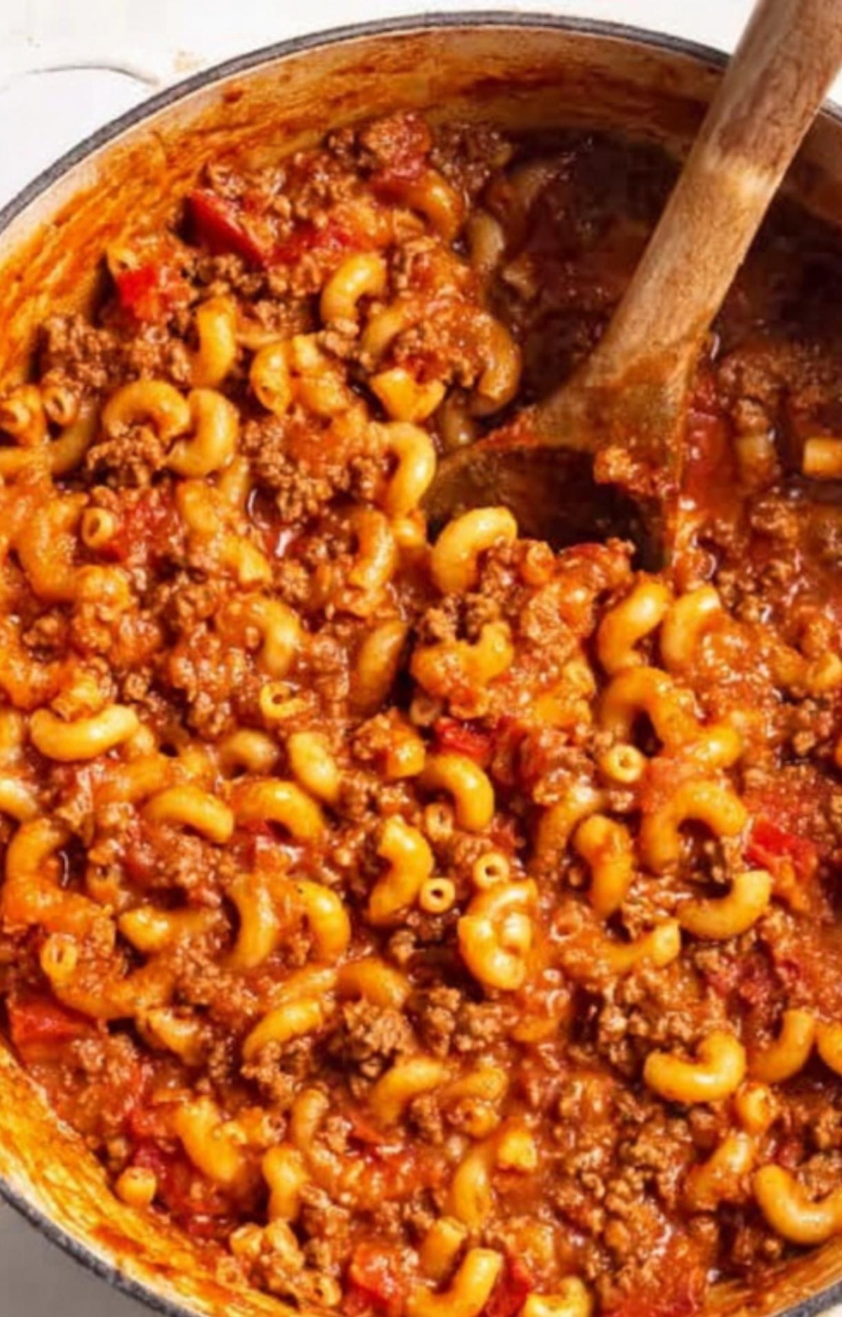 Finished goulash in a Dutch oven, showing elbow noodles, ground beef, and rich tomato sauce ready to serve.