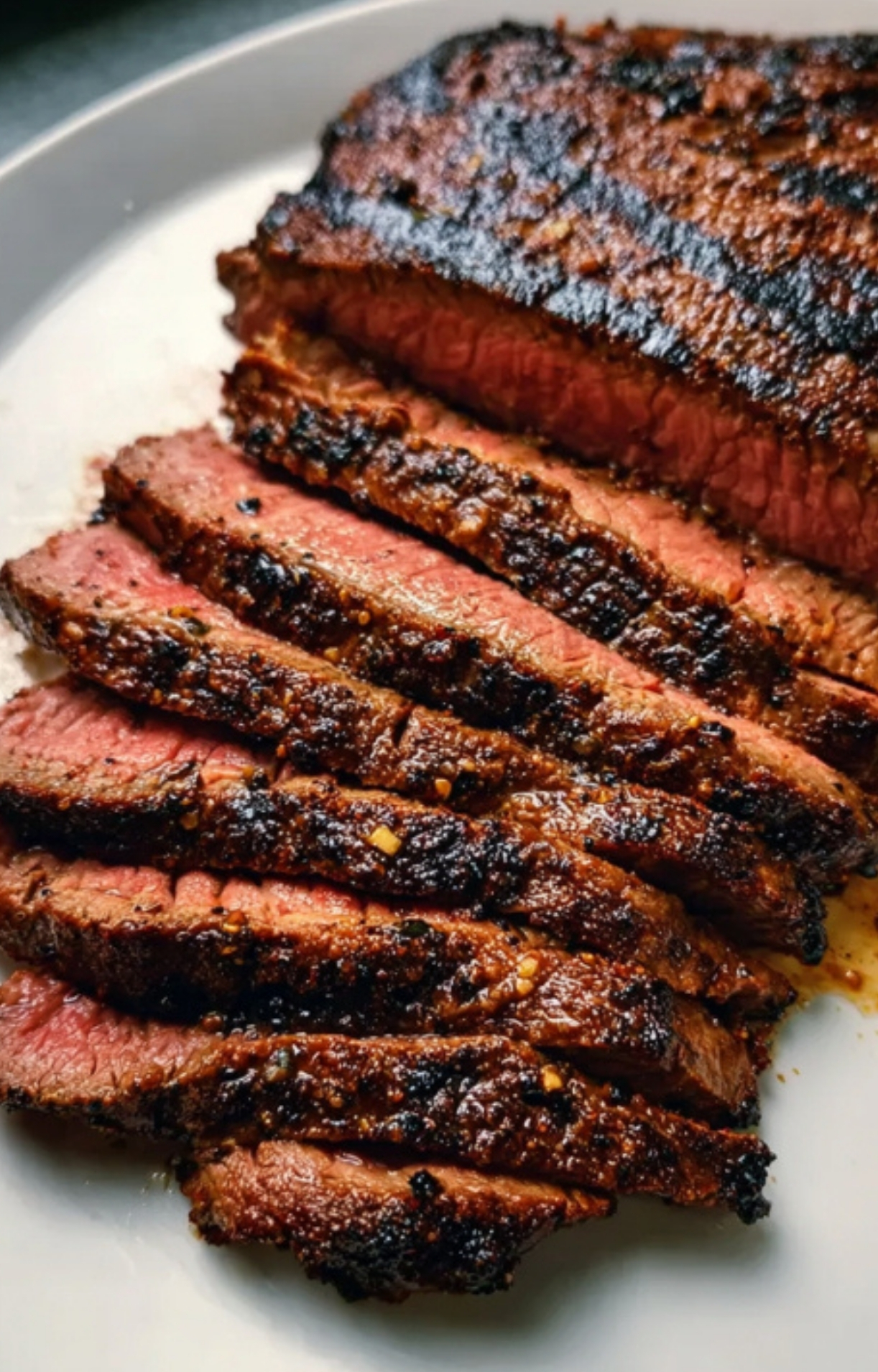 Thin slices of perfectly grilled flank steak, showing a juicy, tender center for an easy weeknight meal.