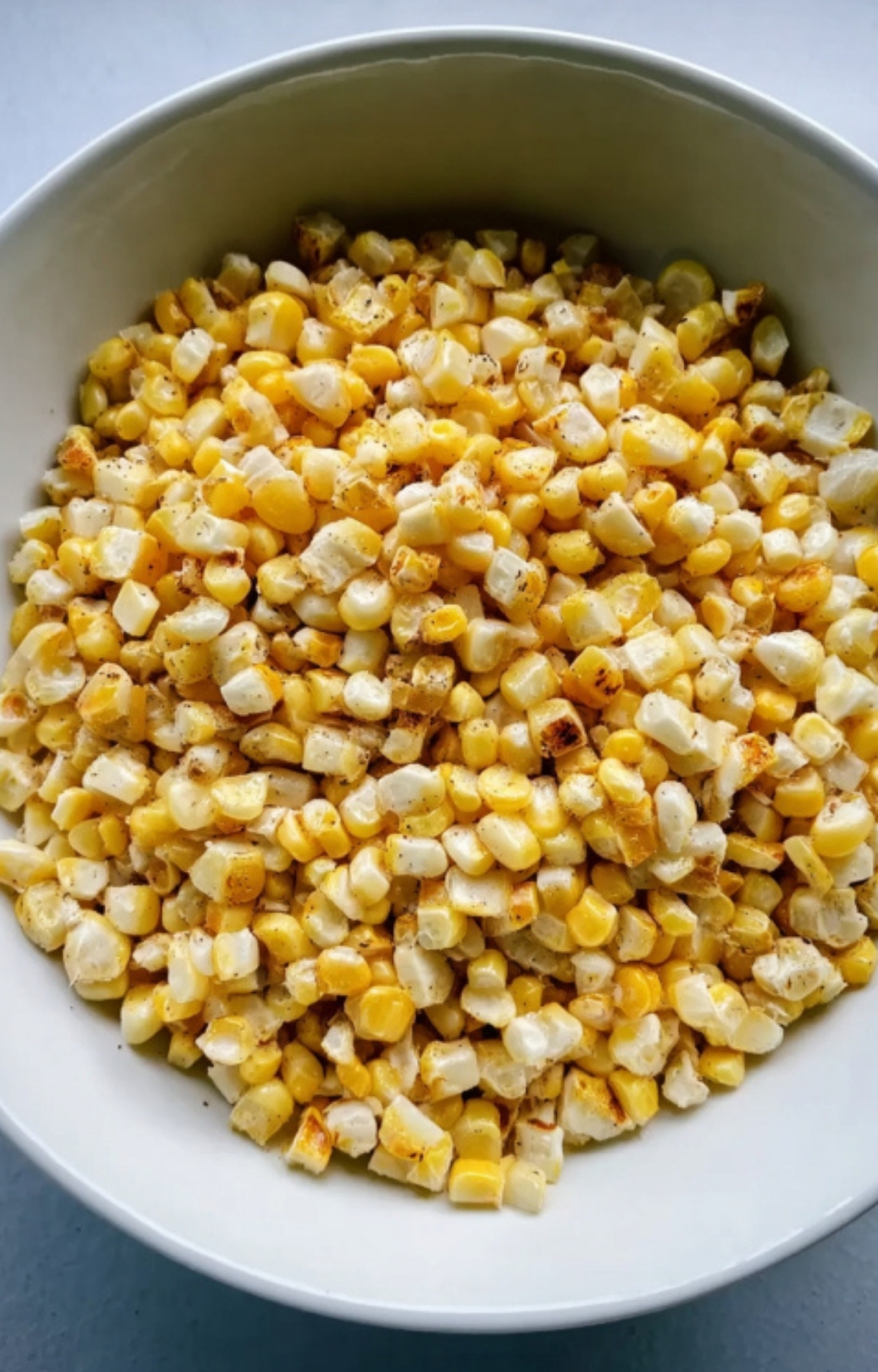 Bowl of charred corn kernels, the base for a quick and healthy summer salsa.