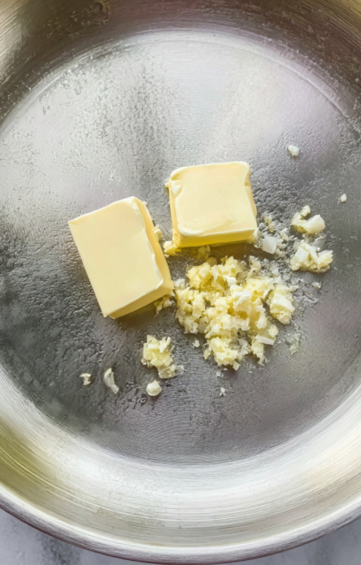 Butter and minced garlic melting in a skillet, the first step for a flavorful shrimp and rice meal