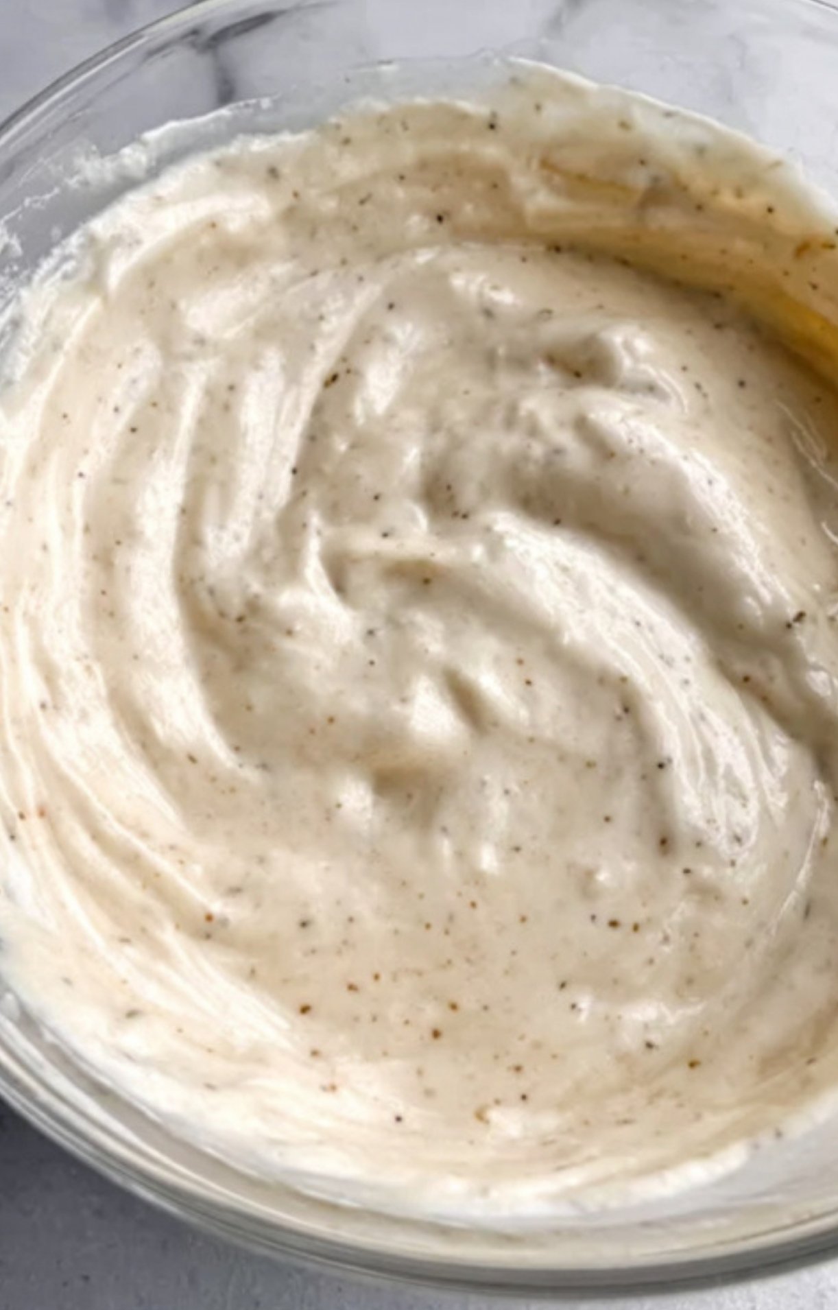 Ranch seasoning, herbs, and spices ready to blend with sour cream for a flavorful potato dish.