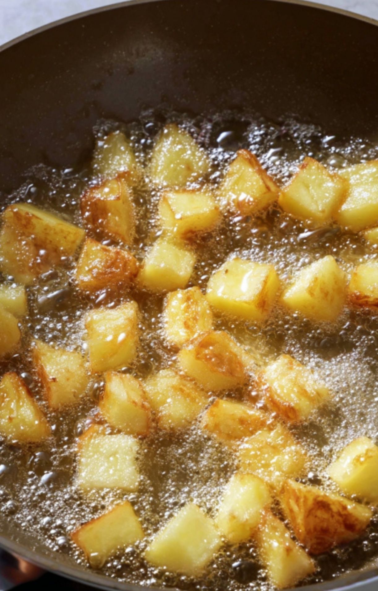 Potato cubes sizzling in oil. Key for crispy potatoes in classic Filipino caldereta, great for special occasions.