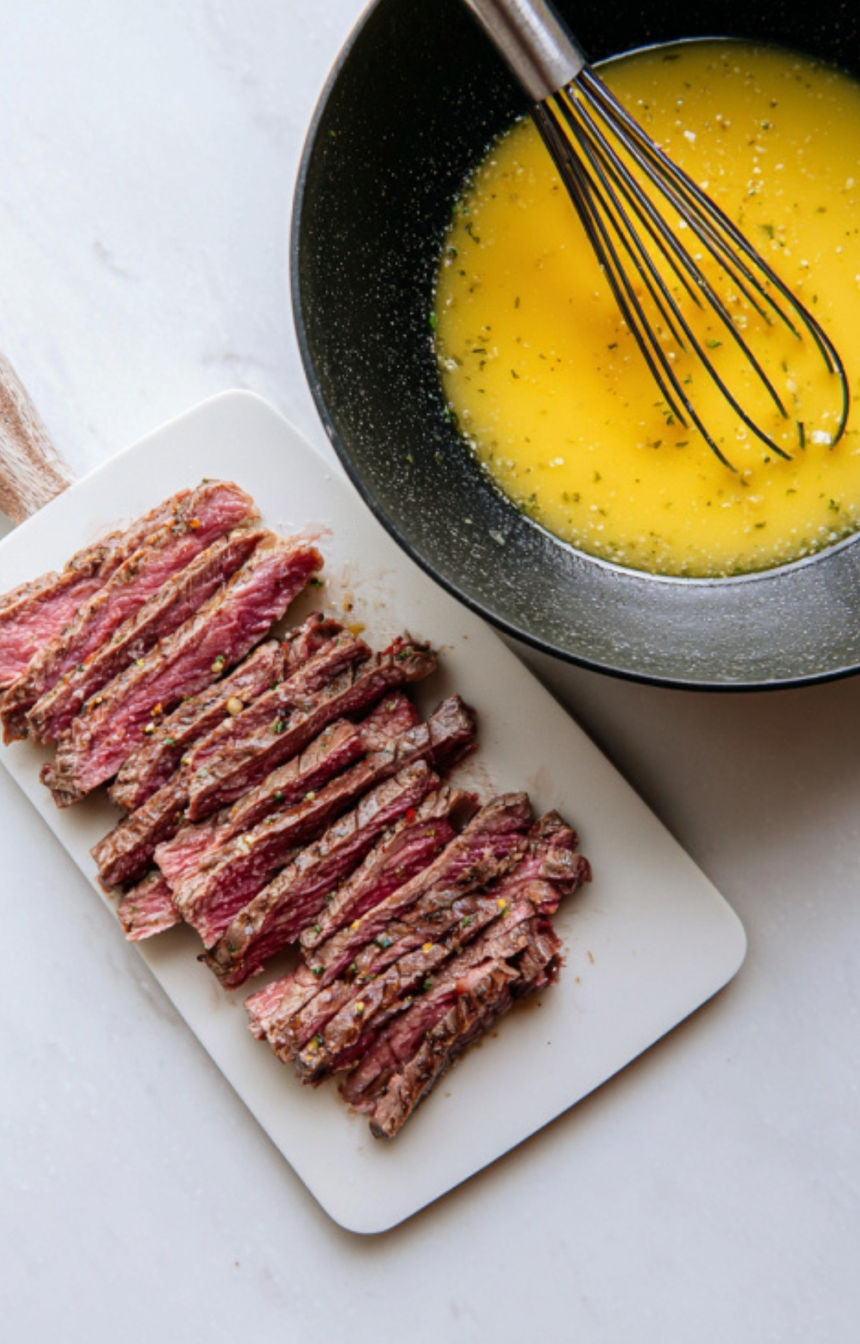 Sliced leftover steak next to a bowl of whisked eggs with seasonings, ready for cooking.