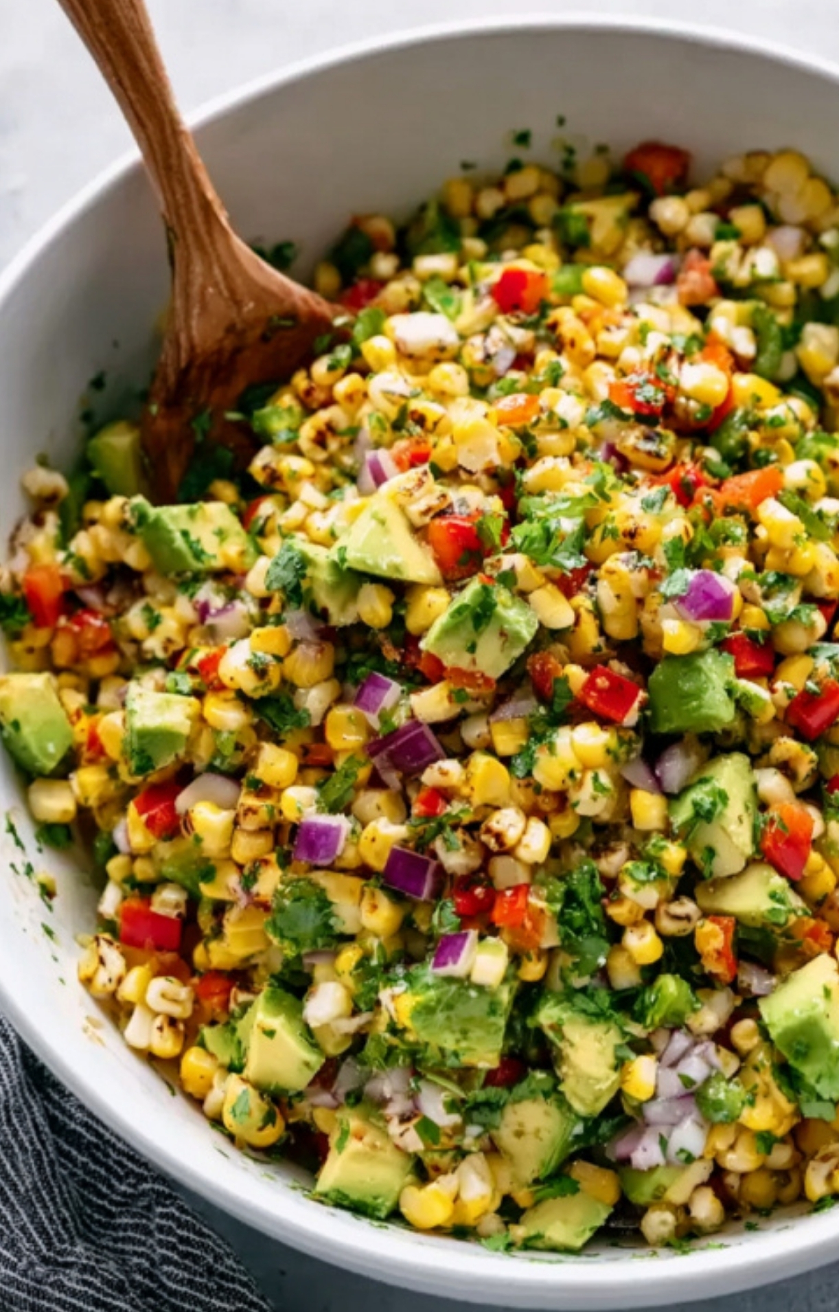 Vibrant bowl of corn salsa with avocado, red onion, and cilantro, an easy side for steak or tacos.
